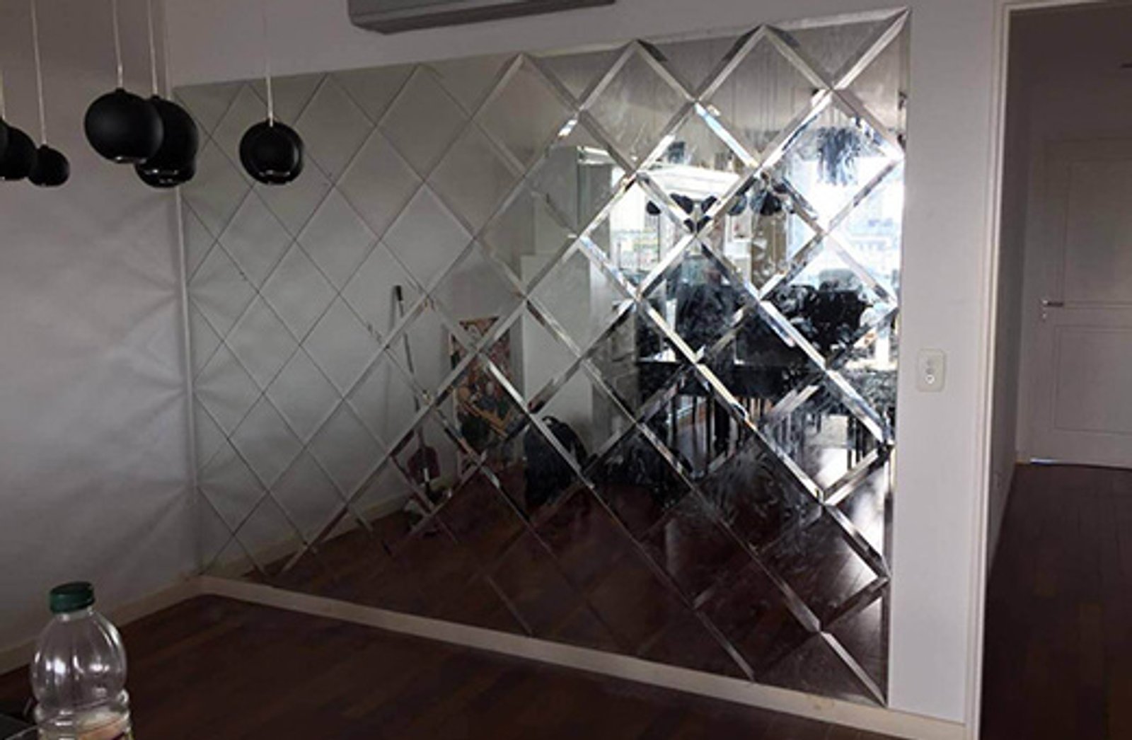 pared de espejos en rombos y lámparas colgantes — proyecto Espejo biselados, por Cristalcenter, en Puerto Madero