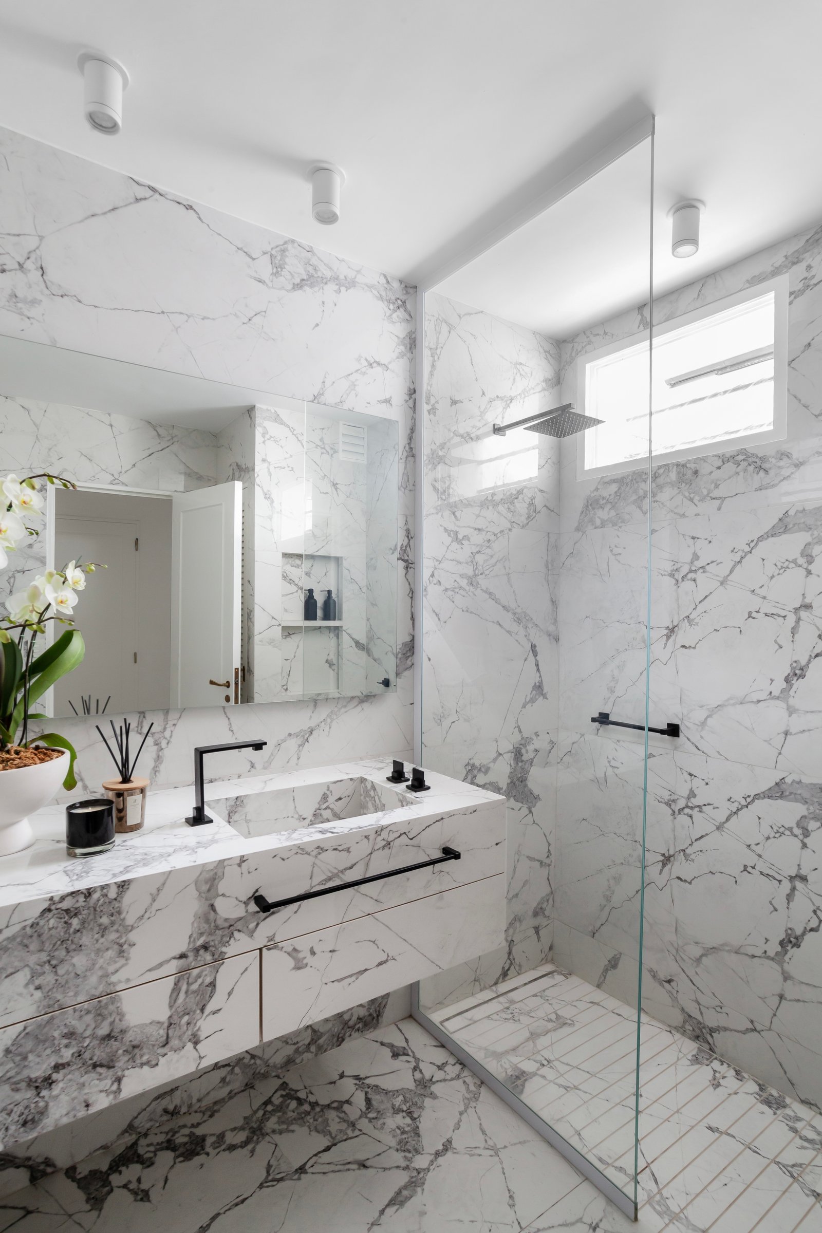 Baño moderno con mármol veteado, lavabo integrado y grifería negra — proyecto Alvear | Redefining luxury, por Ren Studio, en Recoleta