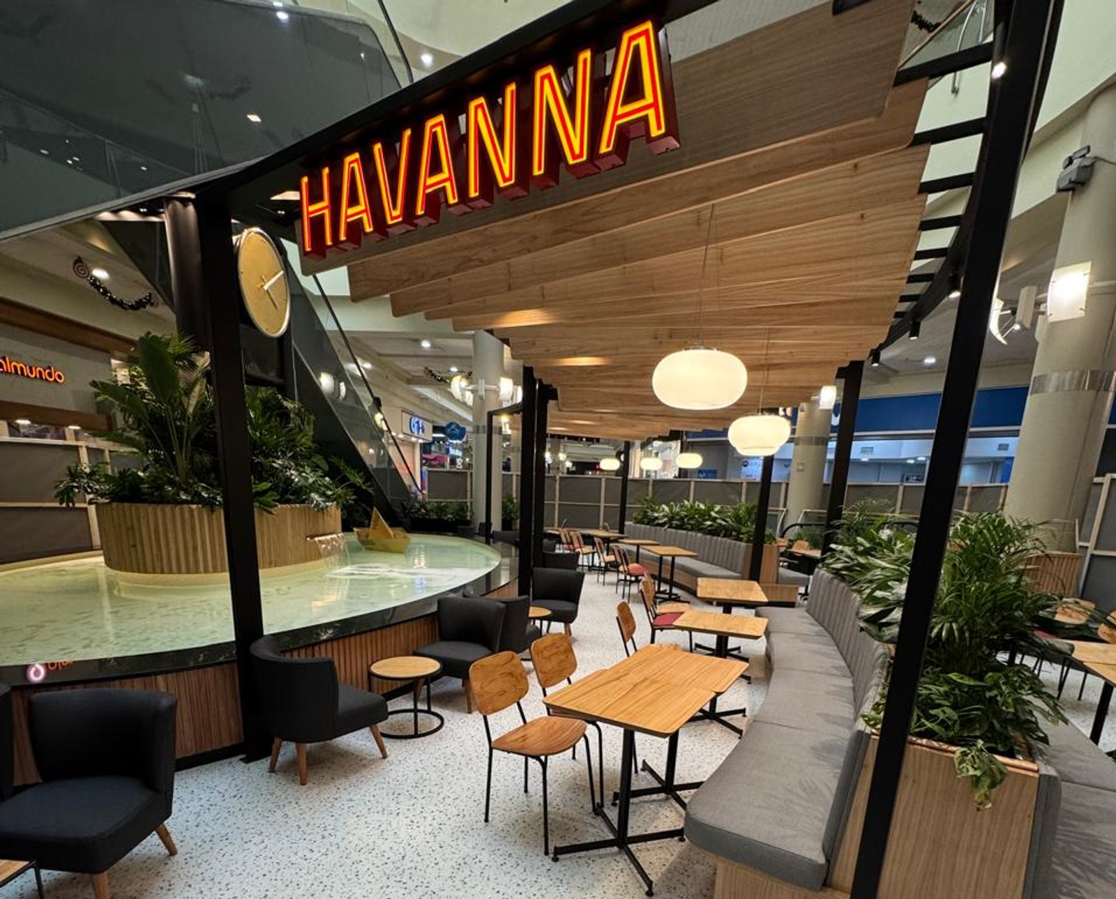 Cafetería moderna con decoración de madera y luces de neón — proyecto Havanna Plaza Oeste Shopping, por COMOTTO - SOMMER  - ARQUITECTOS, en Blvd. Juan Manuel de Rosas 658