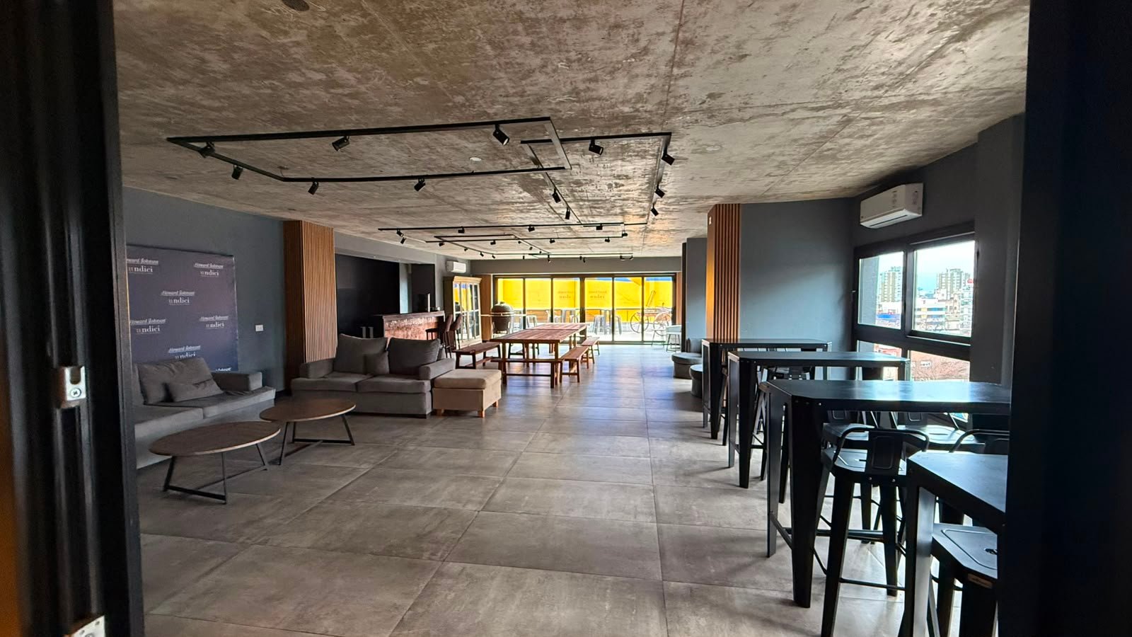 Espacio industrial moderno con living y comedor amplios — proyecto UNDICI - Howard Johnson- La Boca, por COMOTTO - SOMMER  - ARQUITECTOS, en Brandsen 927