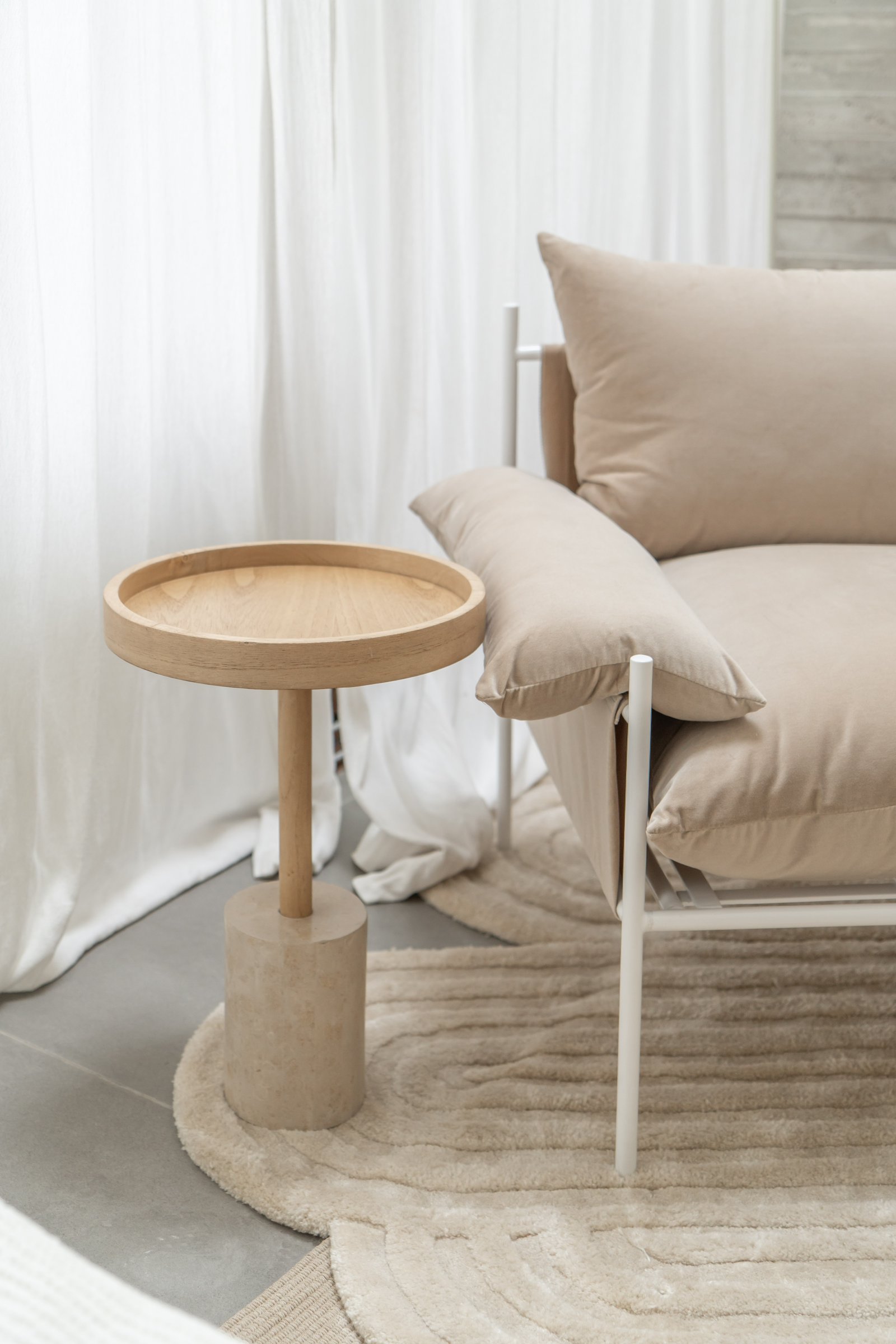 Sala de estar minimalista con sillón curvo beige y mesa de madera — proyecto PROYECTO NAUDIR, por July Acosta Home, en Belén de Escobar