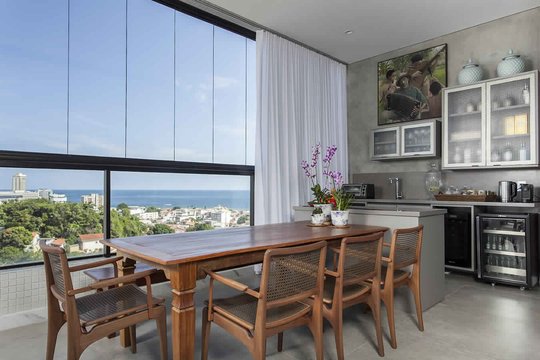 Comedor moderno con vista al mar, mesa de madera y ventanal panorámico — proyecto Gourmet, por Xico Diniz