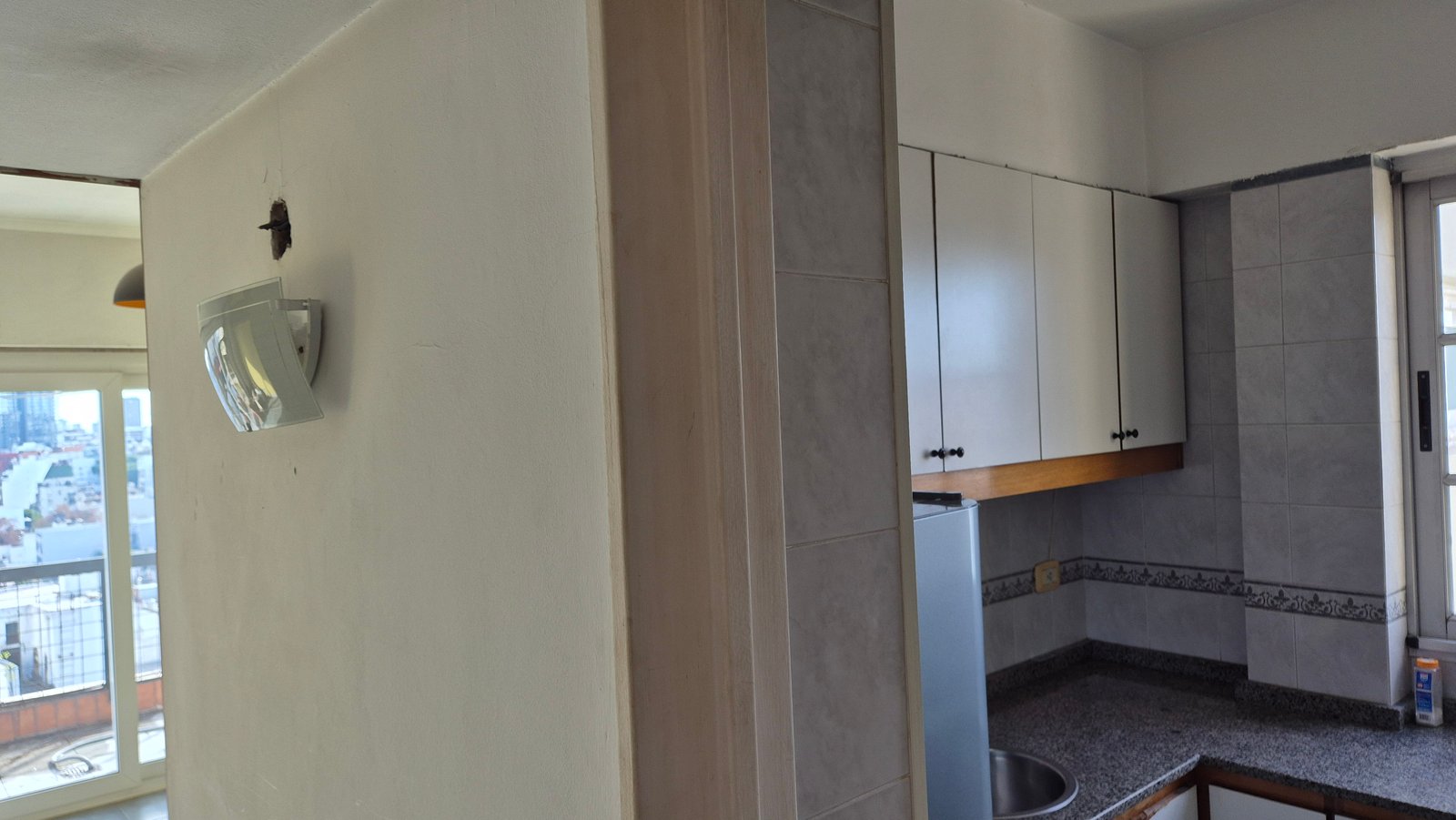 cocina moderna con muebles blancos y luz angular — proyecto Living - Remodelación Soho, por RenovArqui, en Palermo