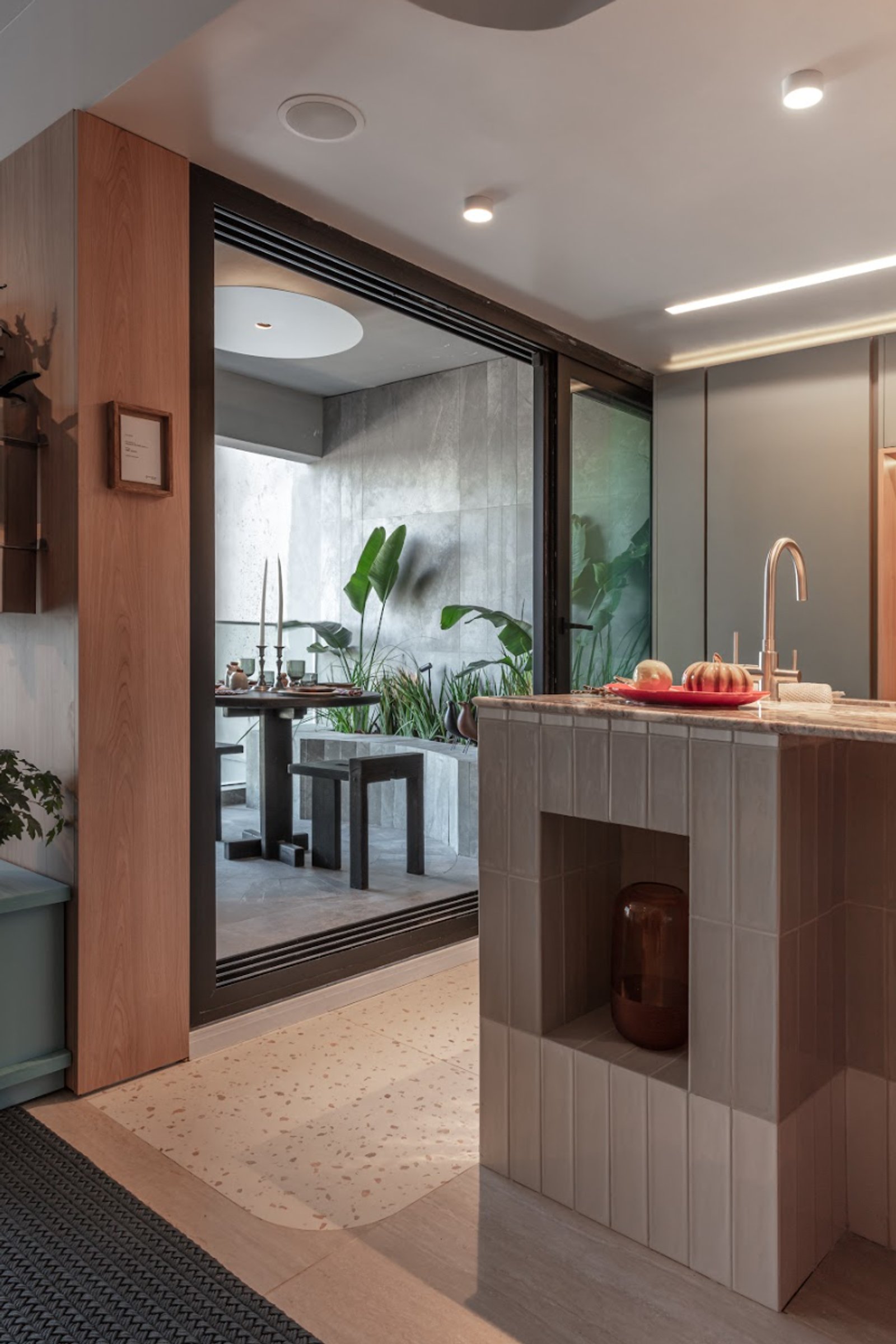 Cocina moderna con isla de cerámica y rincón de comedor en patio interior — proyecto Sara Plazibat, por San Lorenzo Design, en Cam. de los Remeros 1585