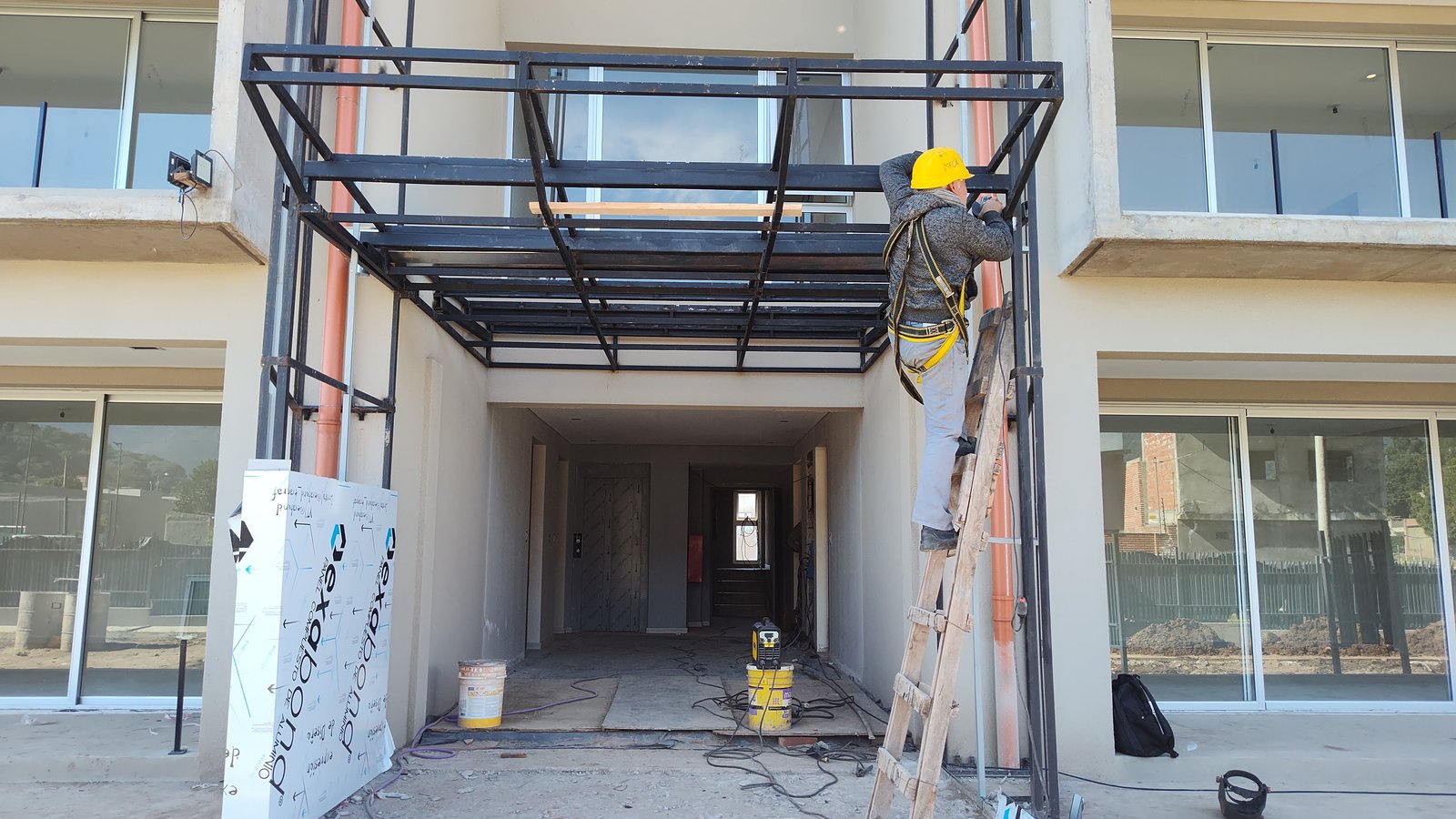 fachada de prédio residencial em construção com toldo metálico — projeto EDIFICIO CHUBUT, por HMCONSTRUCCIONES, em Chubut