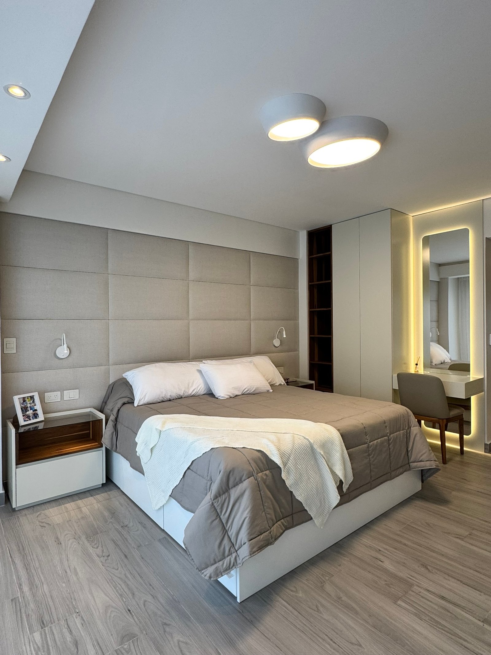 Quarto moderno com painel bege, iluminação indireta e penteadeira integrada — projeto Cerviño, por MDBK Arquitectura, em Palermo