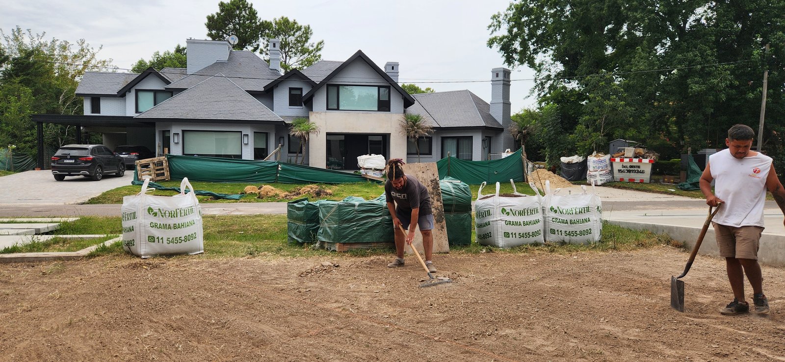 Obra en casa moderna con bolsas de material y paisajismo en proceso — proyecto Casa CAD, por Estudio Rifahi, en Moreno