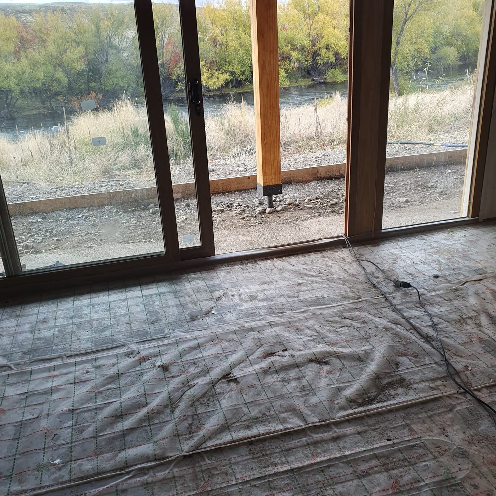 interior en construccion con malla en el piso — proyecto Vivienda a orillas del Río Quilquihue, por TROKEN, en Neuquén