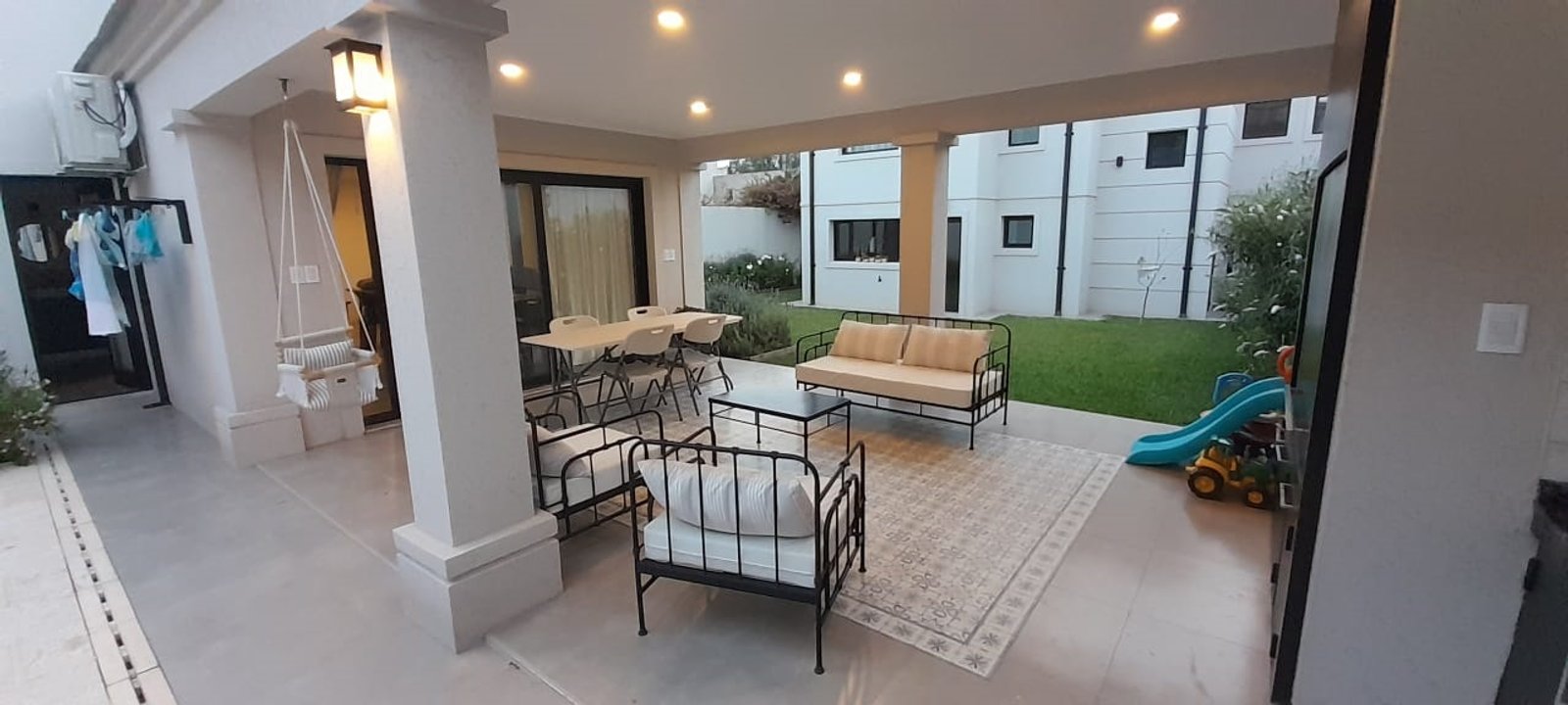 Living comedor exterior con techo y jardín con tobogán — proyecto Casa FF, por Forma, en Balcarce