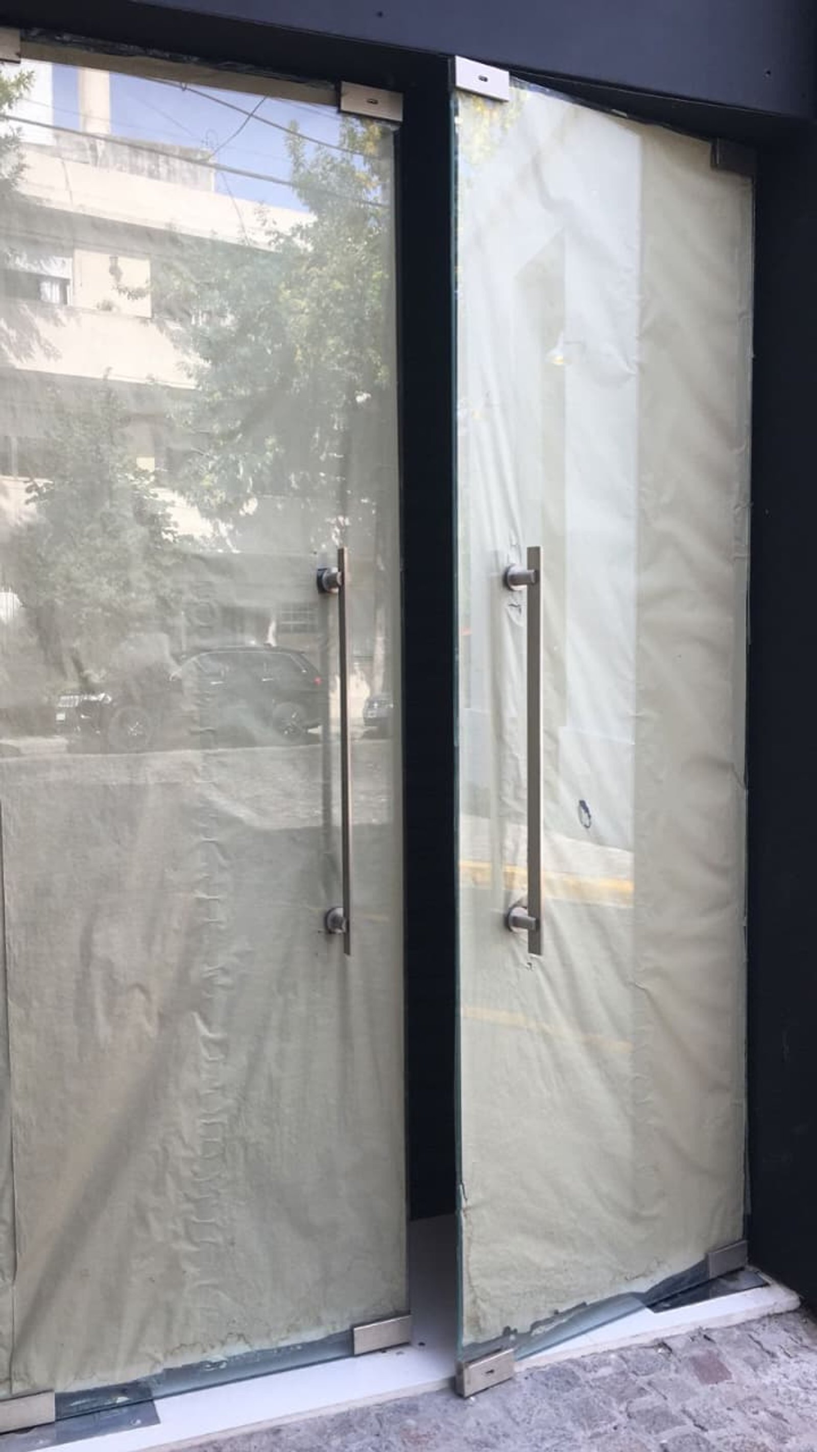 Puertas de vidrio cubiertas en obra con tiradores metálicos — proyecto Puertas 10mm templadas, por Cristalcenter, en Palermo Hollywood