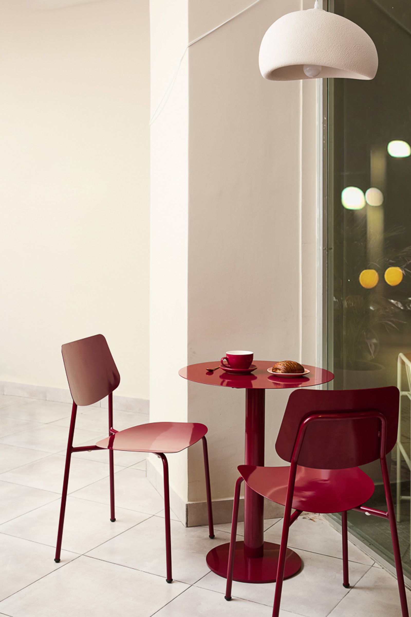 Mesa redonda y sillas de metal en un moderno café — proyecto Severina, por Estudio Plats, en Acoyte 1396
