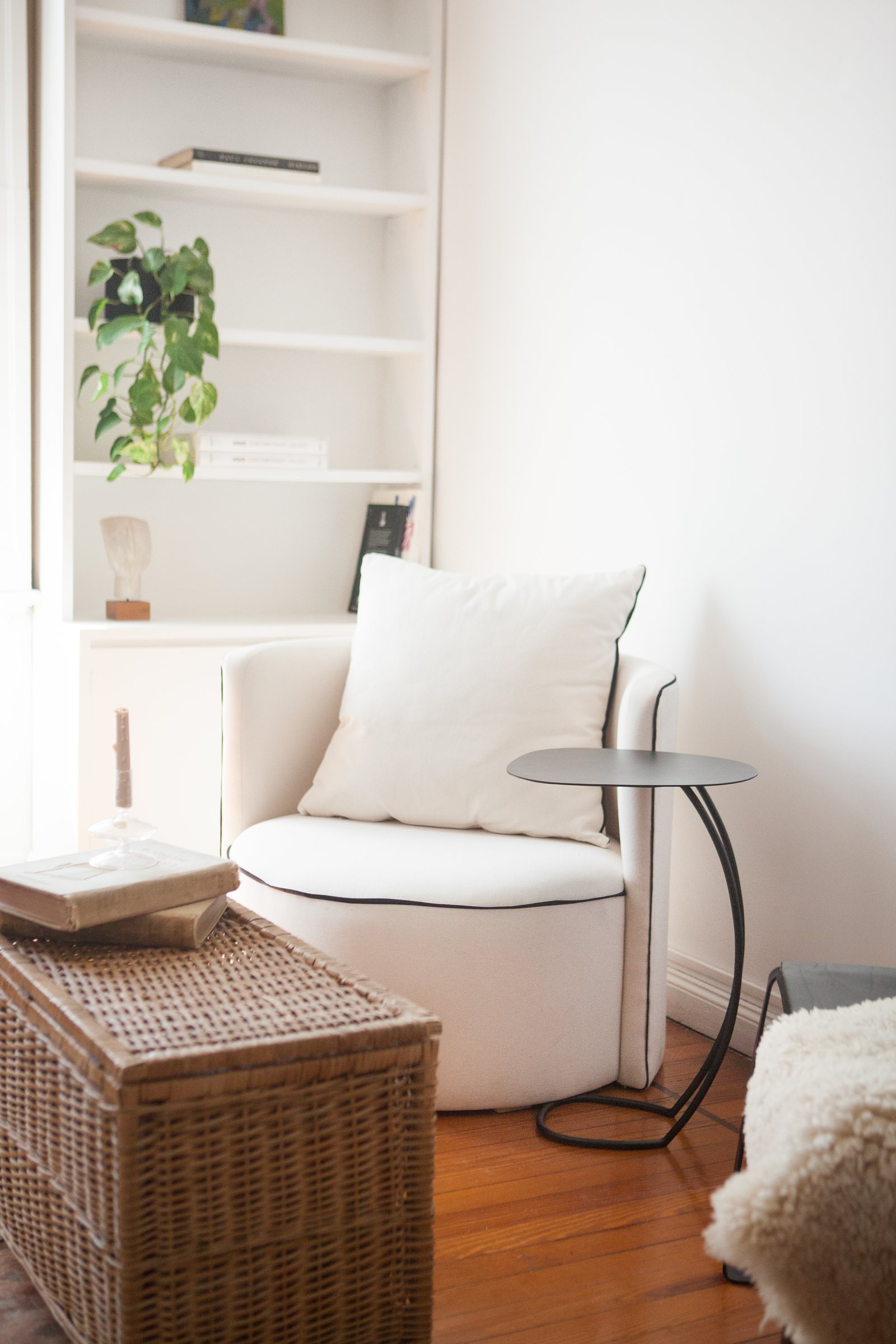 sillón curvo blanco, mesa auxiliar negra, estantería blanca — proyecto Quintana, por LACROZE DESIGN STUDIO, en Recoleta
