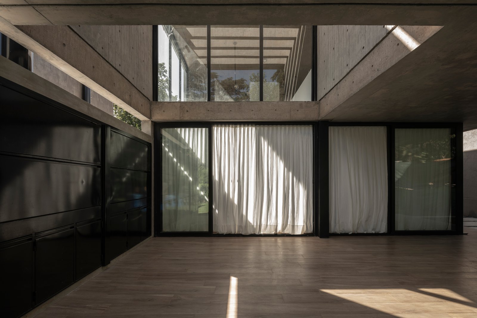 espacio moderno y luminoso con hormigón y madera — proyecto Casa Emilia, por Grupo CRBN, en Parque Leloir