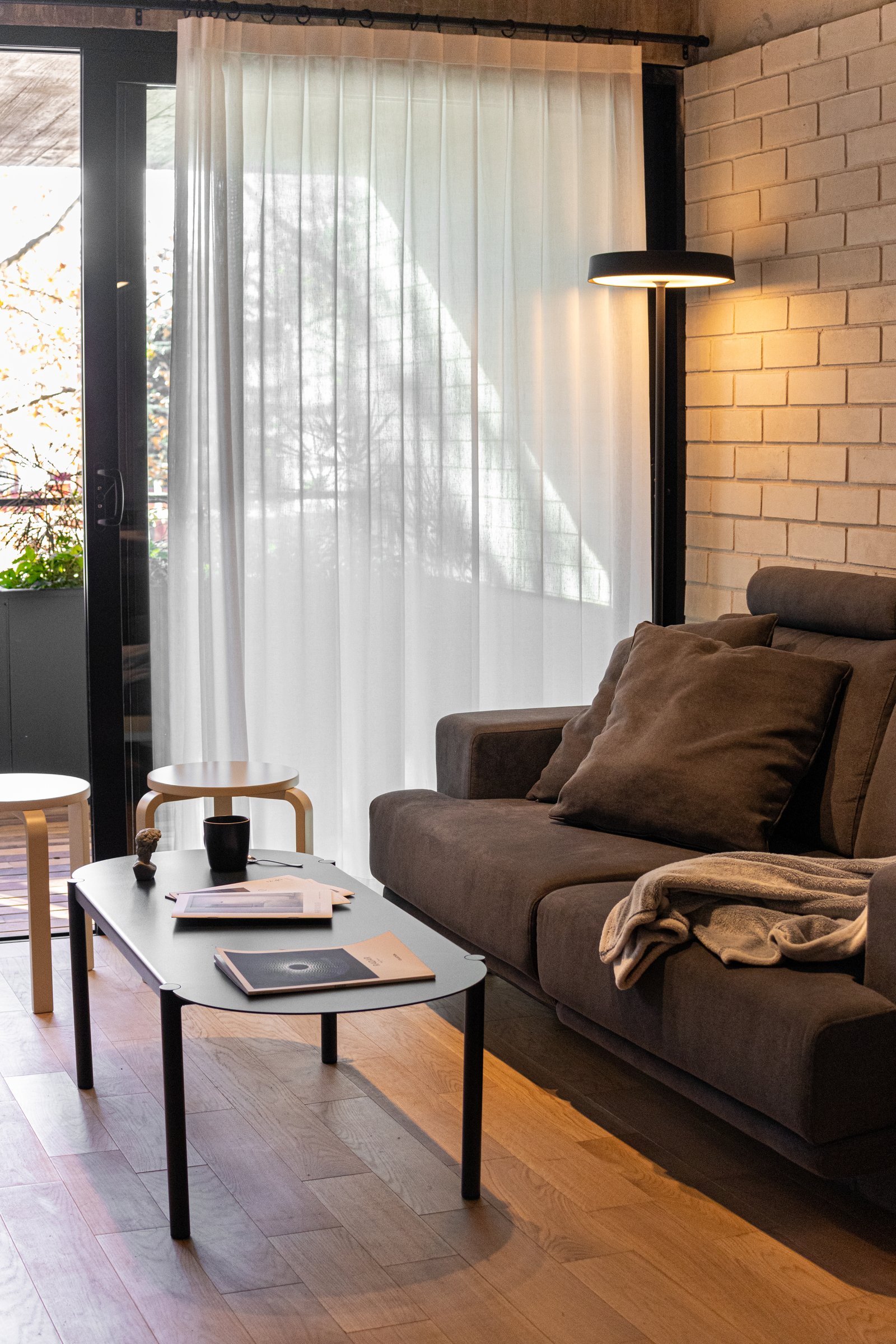 Living moderno con ladrillo expuesto, sofá gris y luz de pie — proyecto Guatemala , por KUPERDESIGN CONSTRUCCIONES SRL, en Palermo