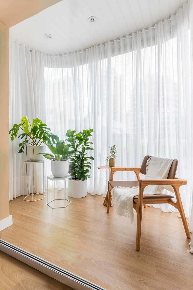 Apartamento tem sala e varanda integrados com muita luz natural e aconchego