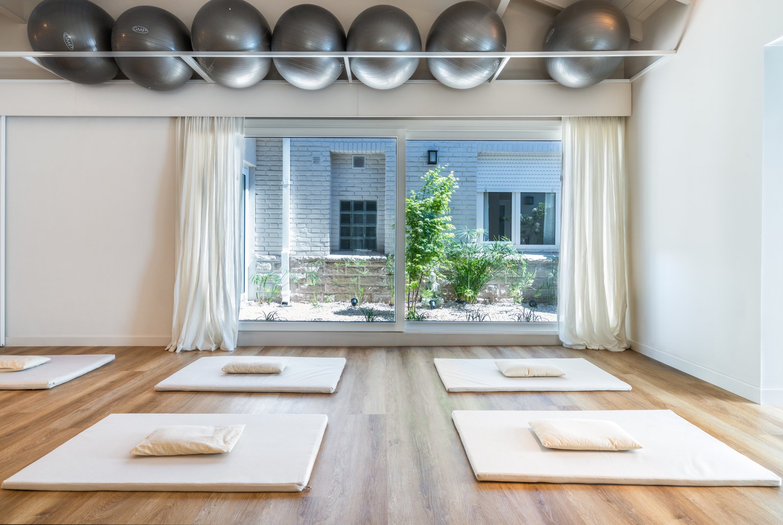 Estudio de yoga moderno con pelotas de ejercicio suspendidas — proyecto ALMA MATTER, por Maria Menna Arquitecta, en Mar del Plata