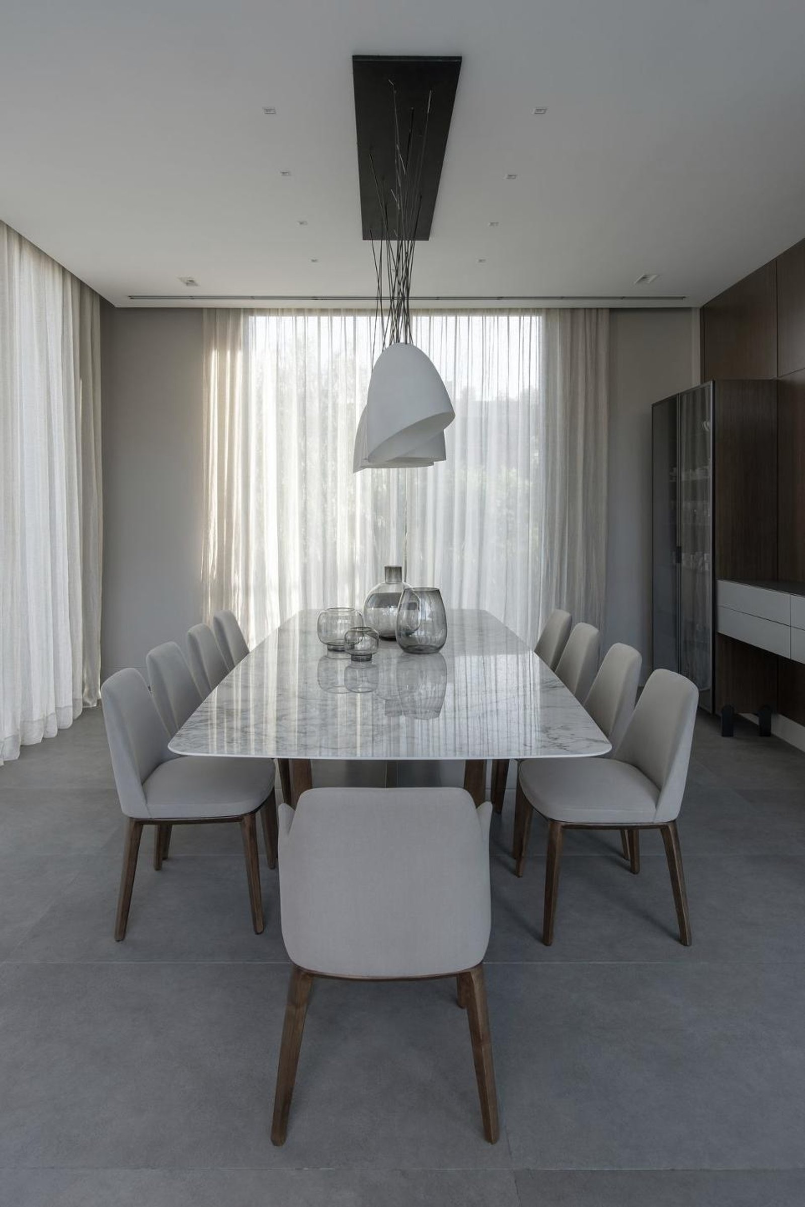 Sala de jantar moderna com mesa de mármore e luminária abstrata — projeto Espacios, por BURANI, em Martínez