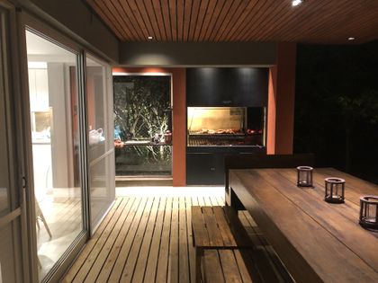 Área de quincho y comedor exterior con deck de madera y techo de listones — proyecto MLS3 - Casa en Santa Bárbara, por MLS Estudio, en Benavidez