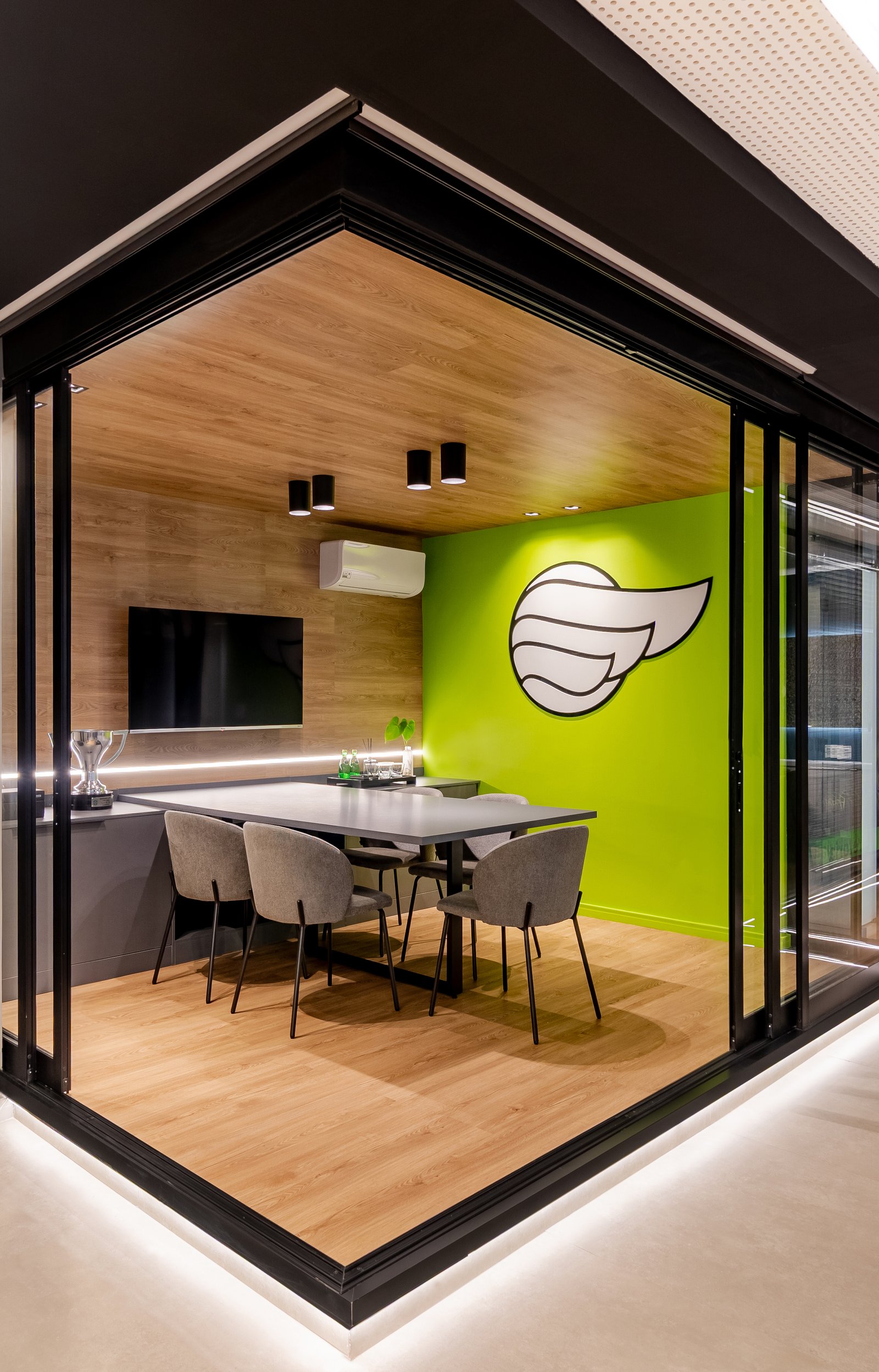 Sala de reunião moderna com parede verde e detalhes em madeira — projeto Projeto PS, por Felipe Rohen, em Itaboraí