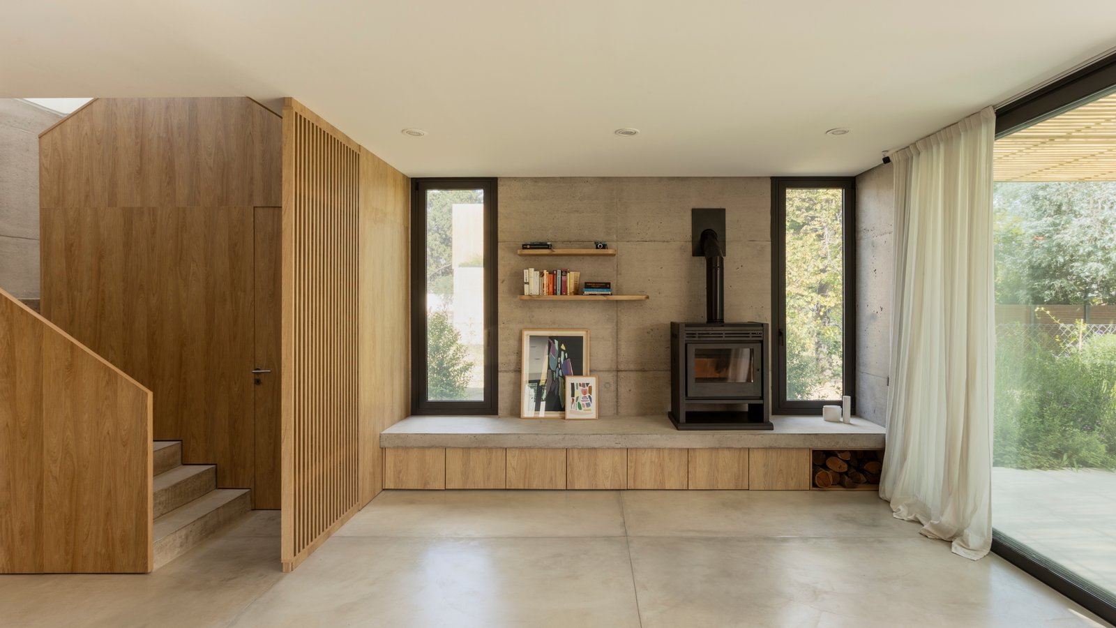Sala de estar moderna com lareira e painéis de madeira — projeto CASA CC, por Rastro Estudio, em San Isidro