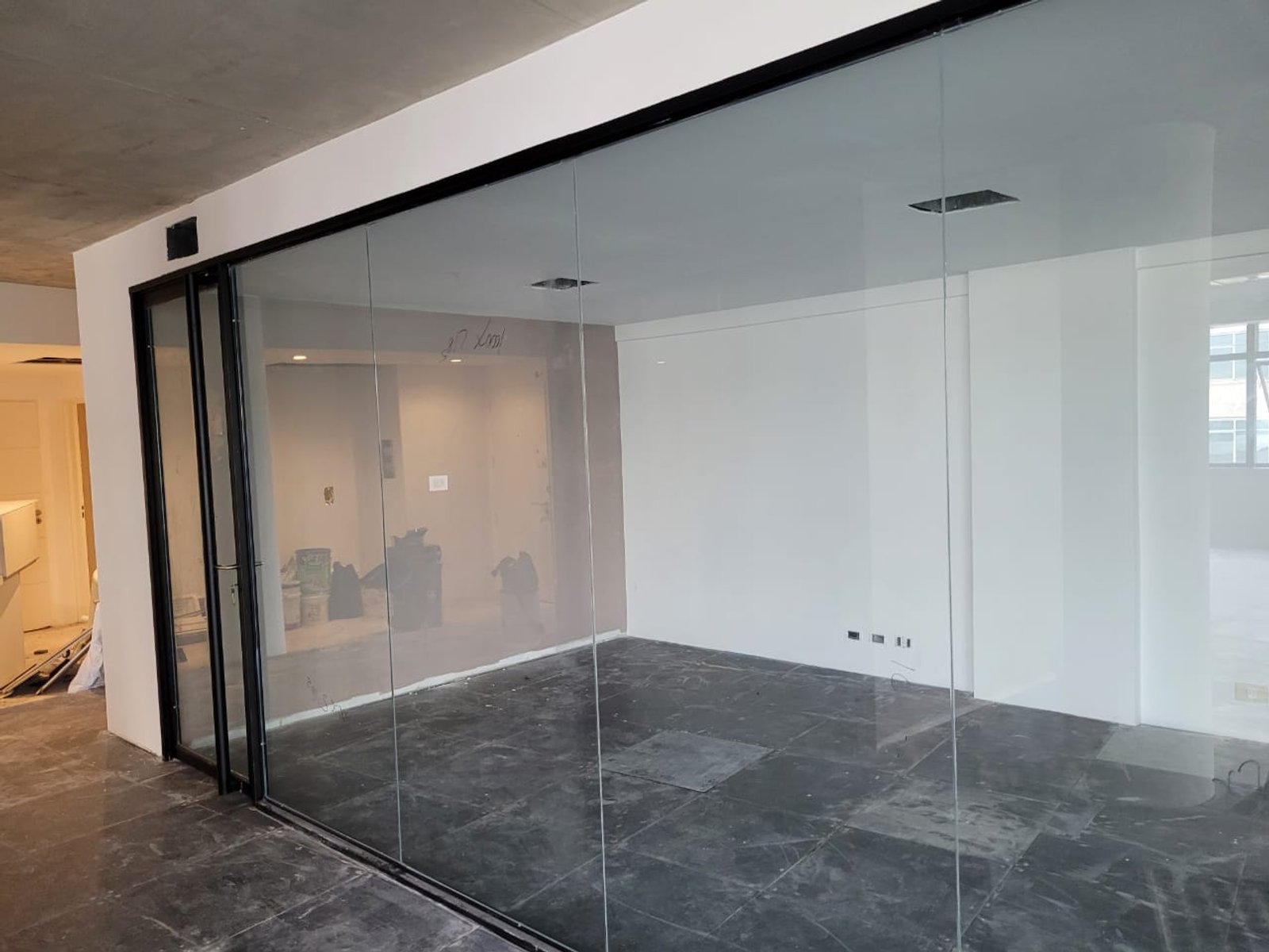 Oficina moderna con mampara de cristal y suelo de mármol gris — proyecto Cerramientos en Bindex 4+4, por Cristalcenter, en Parque Patricios
