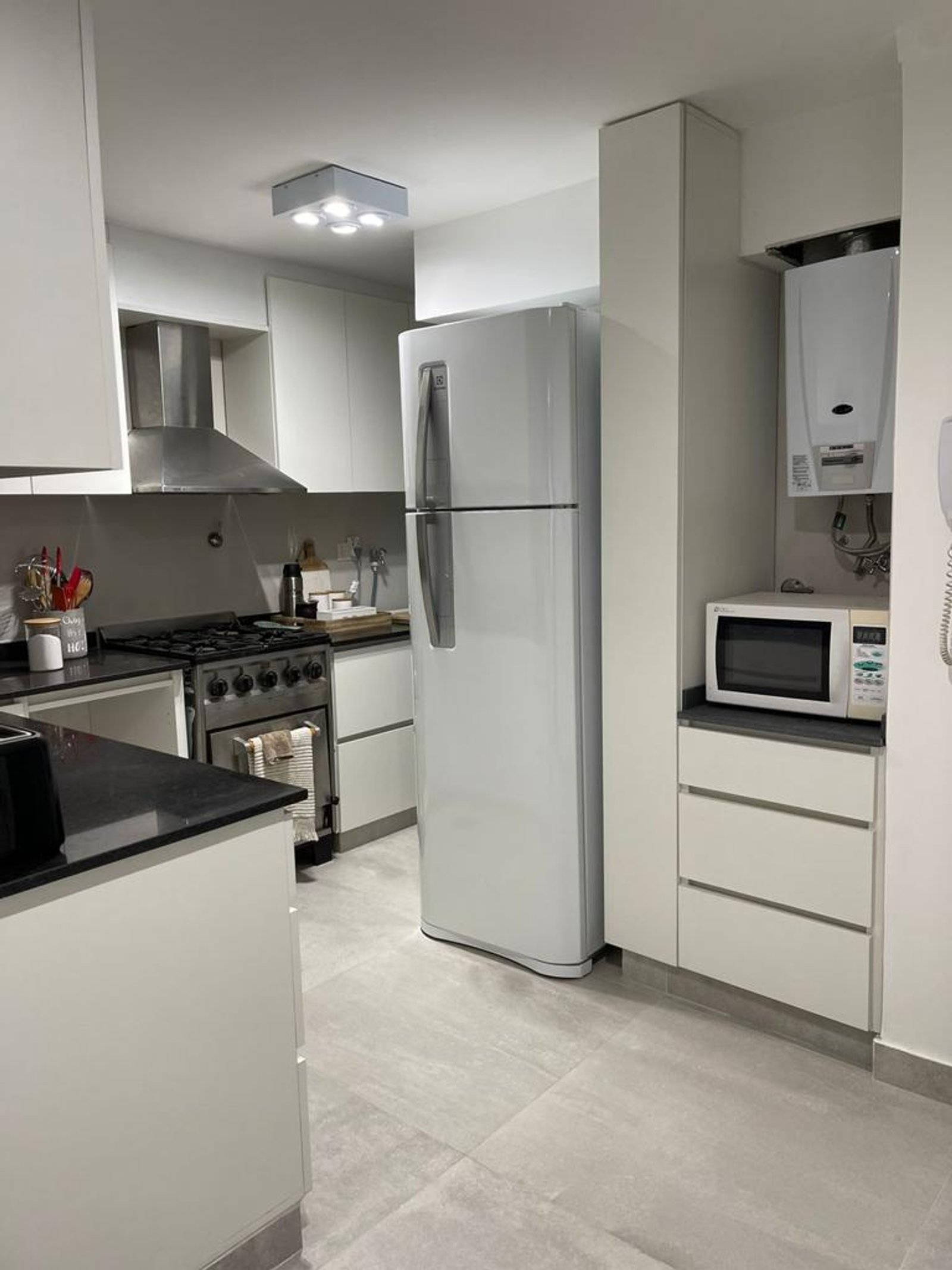 Cocina moderna con electrodomésticos de acero inoxidable y muebles blancos — proyecto Olazabal, por Estudio NET Arquitectura , en Olazábal 3228