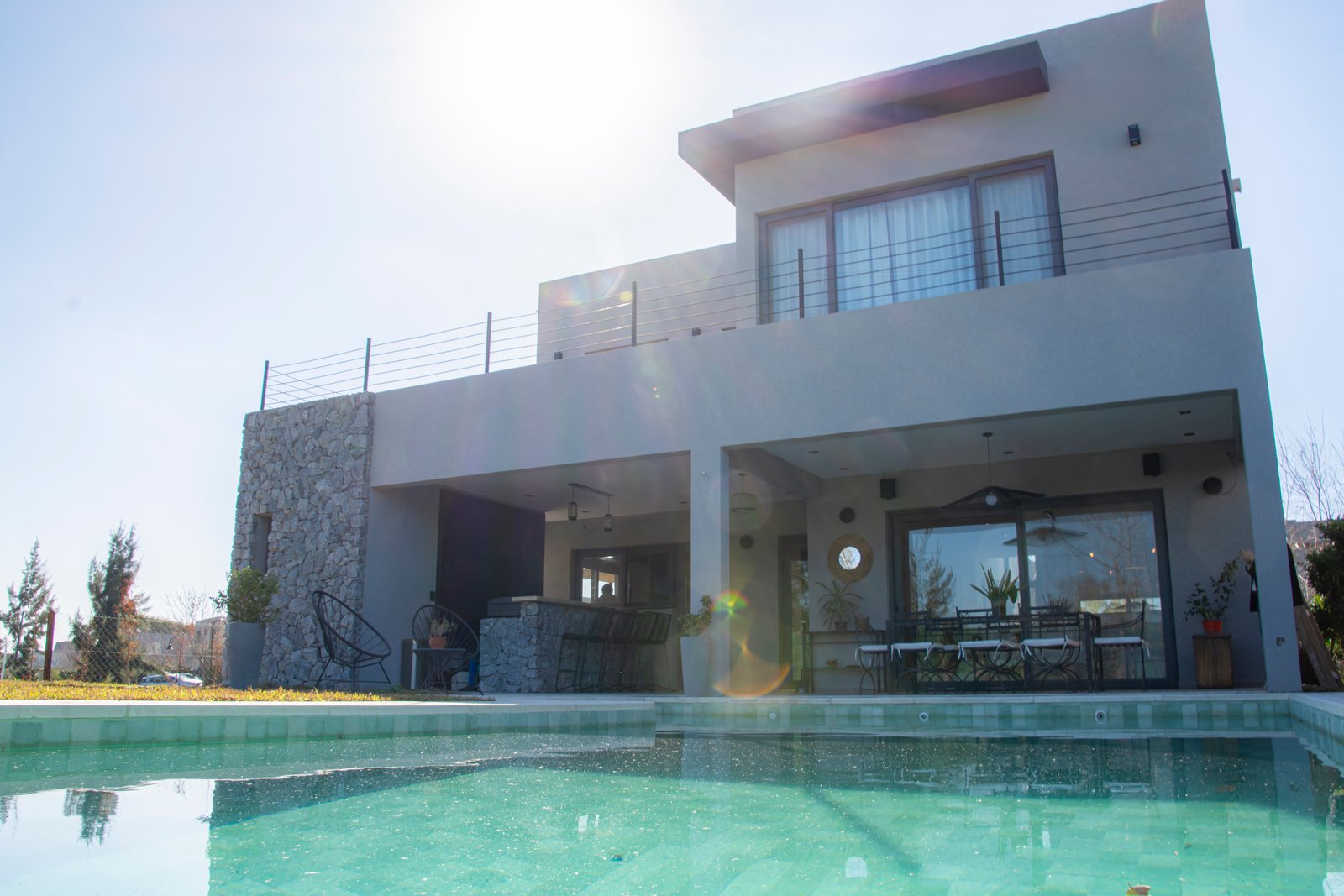 Fachada moderna con piscina y mobiliario exterior — proyecto Casa Tipas, por MSMC, en Сармьенто 3830