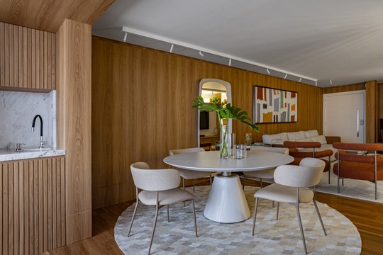 Comedor moderno con mesa redonda de madera y sillas de tela — proyecto Apartamento Único, por BFE INTERIORES, en Jaraguá do Sul - Barra do Rio do Cerro