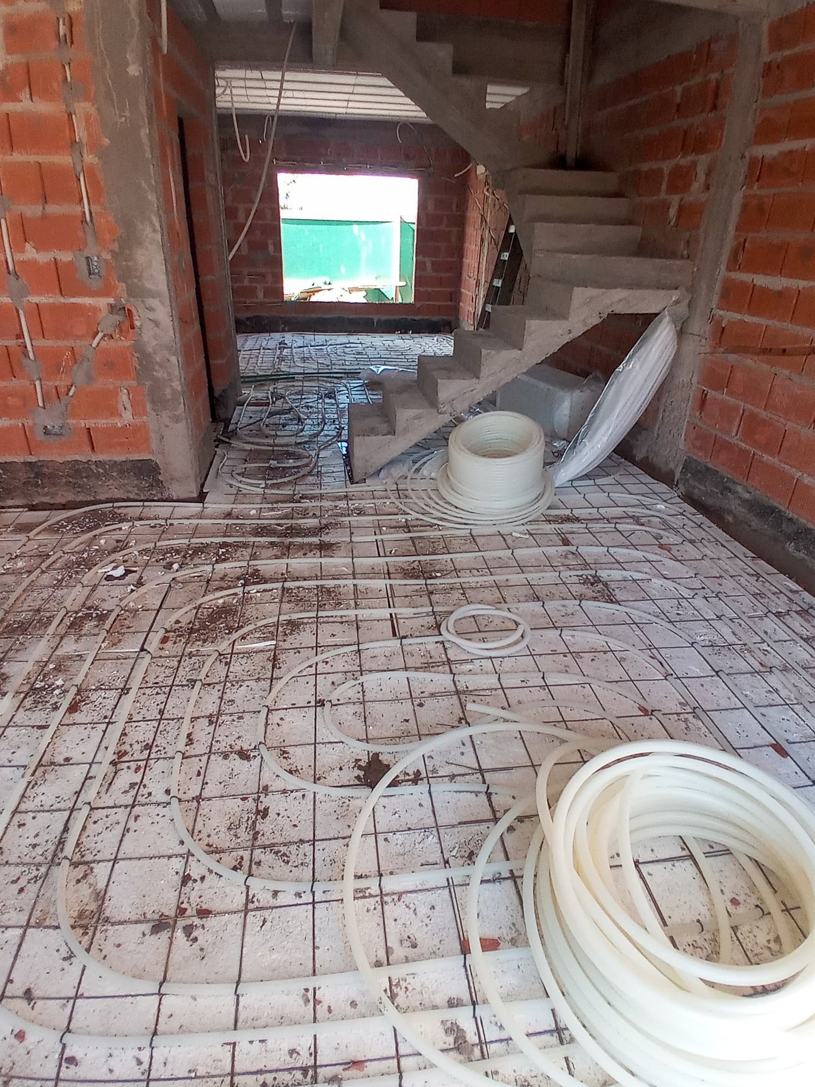 obra de casa con caños para piso radiante y escalera — proyecto Instalación de piso radiante en Barrio Maria del Buen Ayre, por Climatizacion HD, en Av. de la Rivera 4499