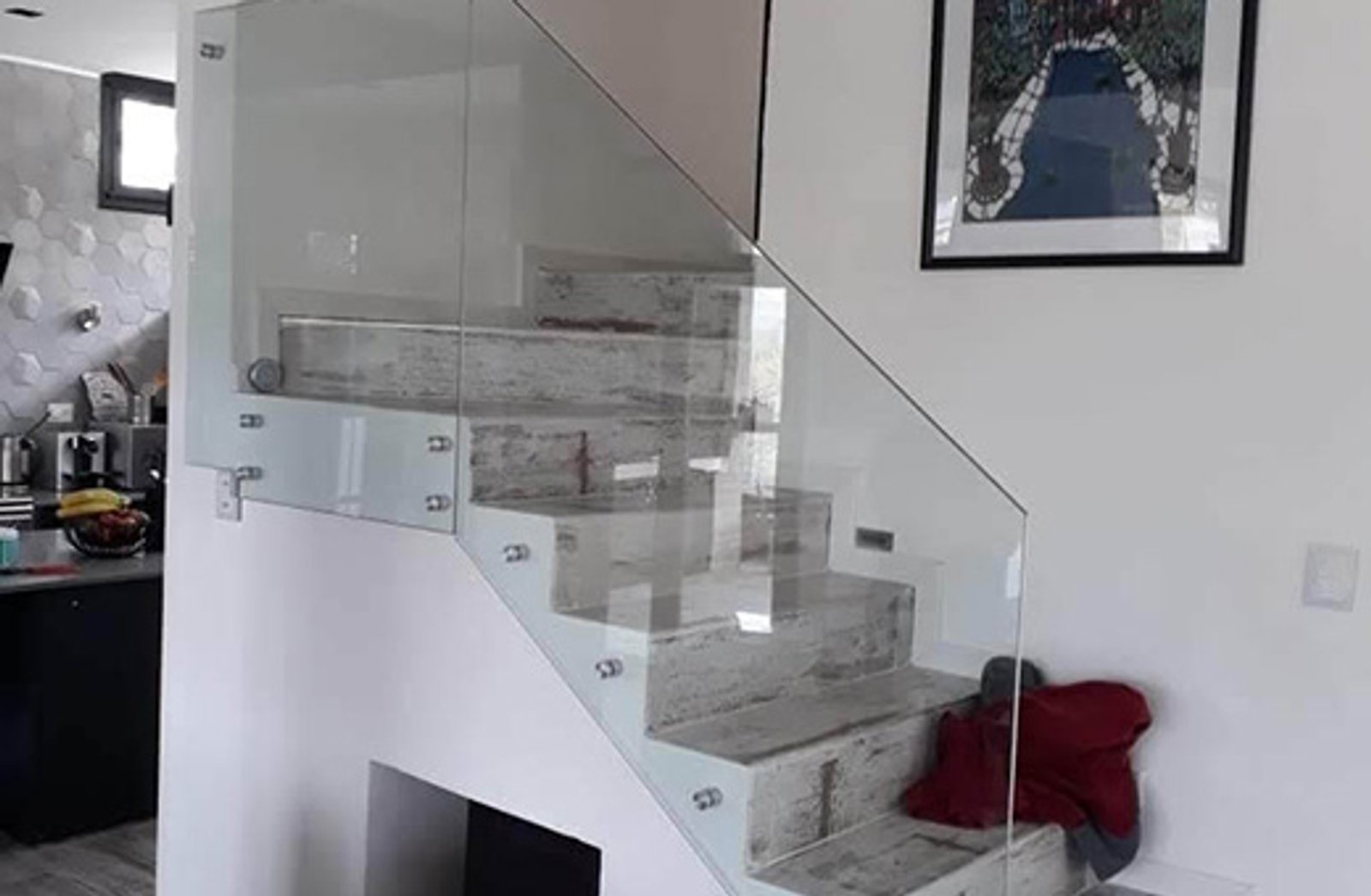 Escada flutuante moderna com corrimão de vidro e obra de arte — projeto Baranda 10mm incolora templada con botones 38mm aluminio, por Cristalcenter, em Palermo