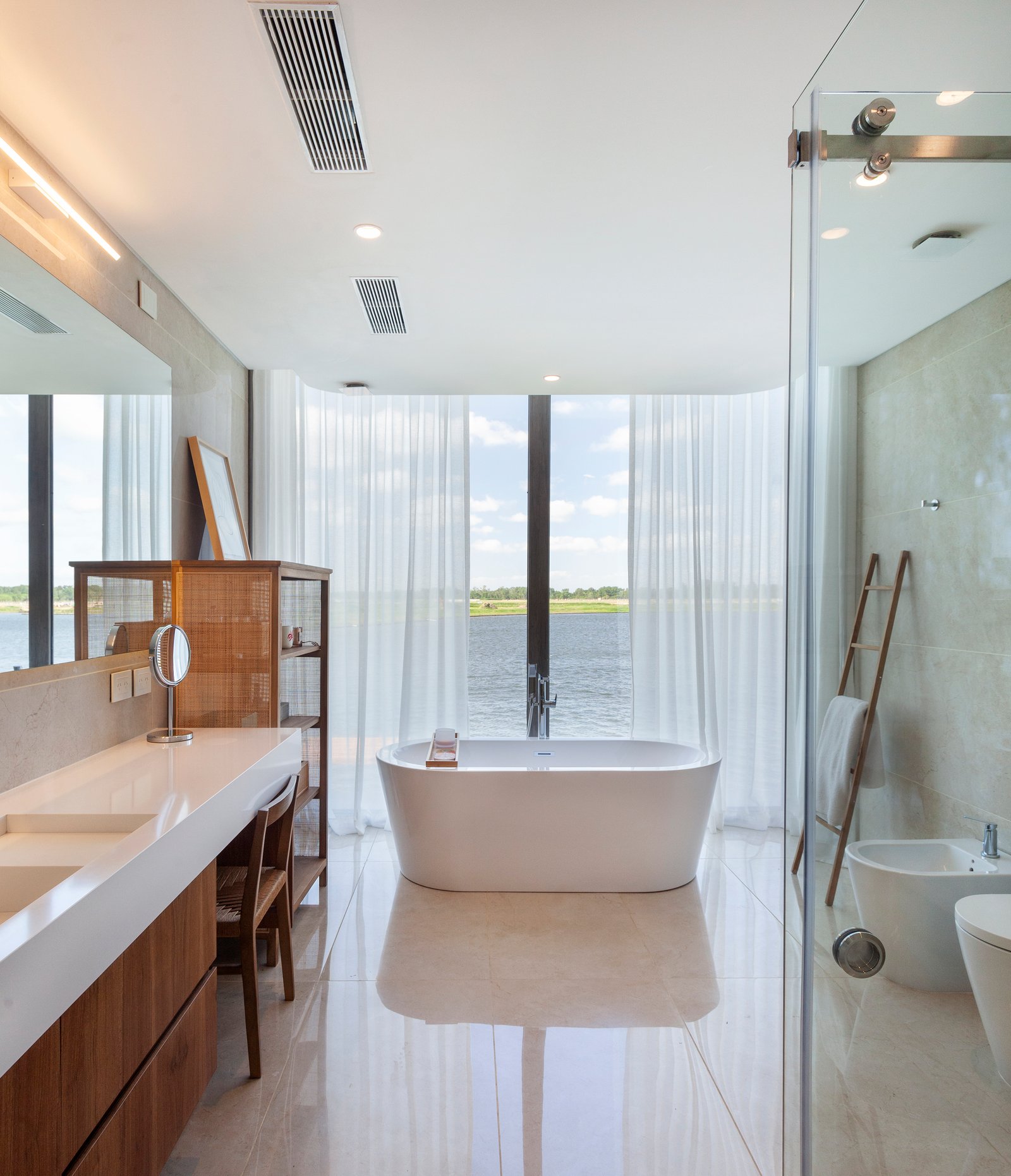 Baño moderno con bañera exenta y vista al agua — proyecto CASA M40, por A'PRIMA - Arquitectura Sustentable, en Unnamed Road