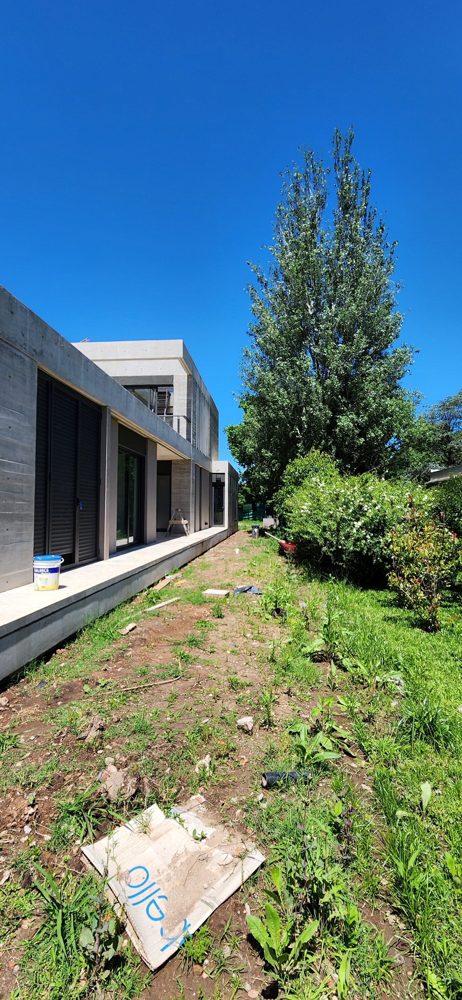 fachada moderna de hormigon con jardin desprolijo — proyecto Casa CAD, por Estudio Rifahi, en Moreno