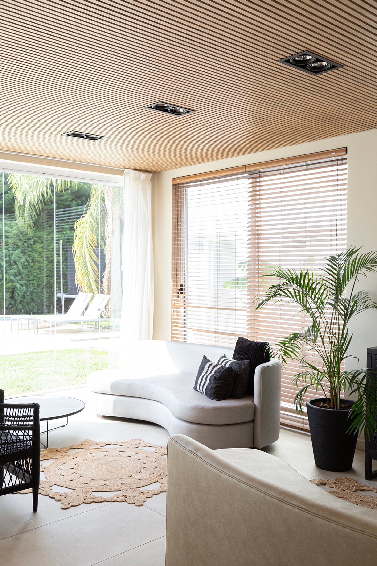 Living moderno con sofá curvo y techo de madera — proyecto Casa Canning, por Gaby Alfonso, en Canning