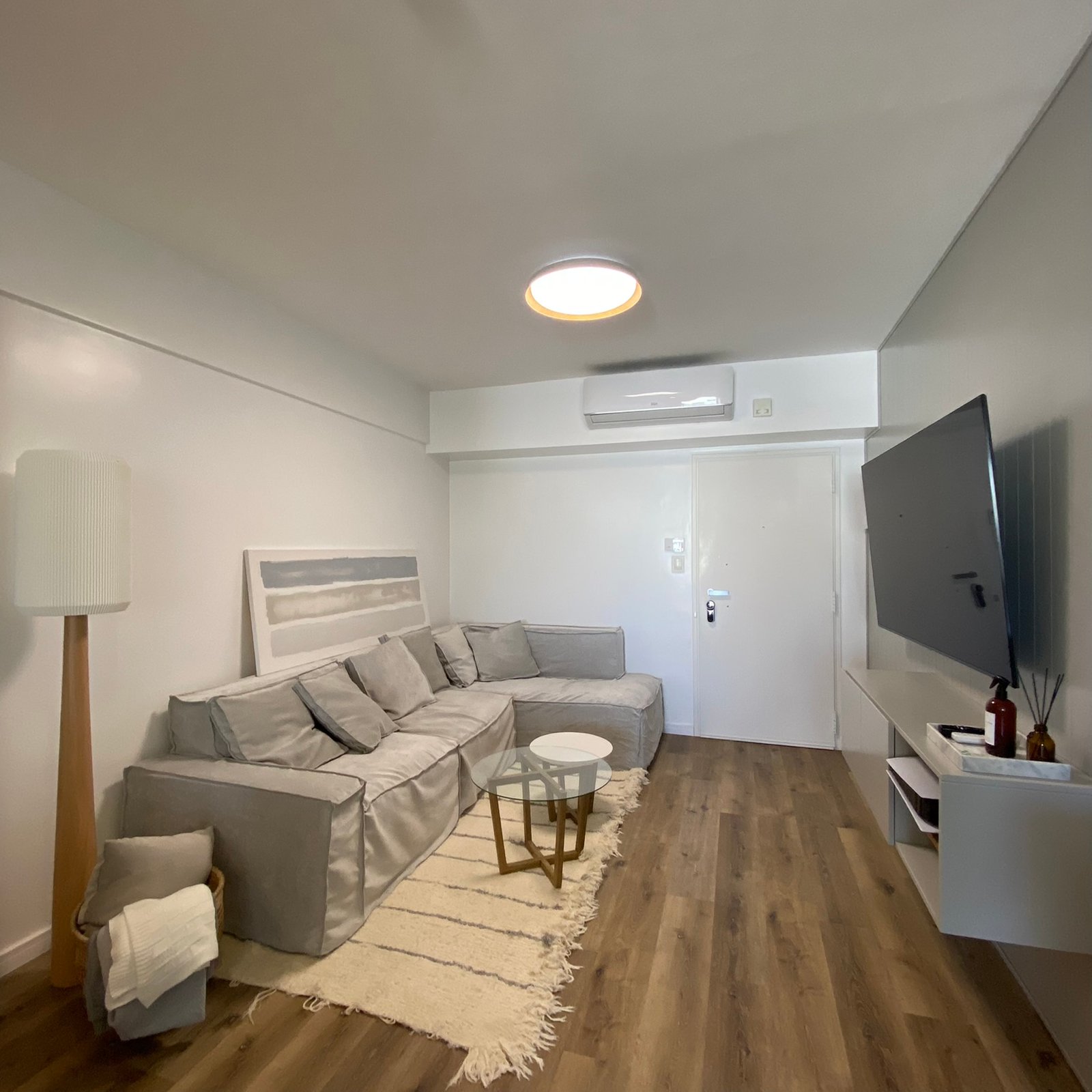 Living moderno escandinavo con sofá modular y mesa de centro redonda — proyecto Burela, por MDBK Arquitectura, en Villa Urquiza