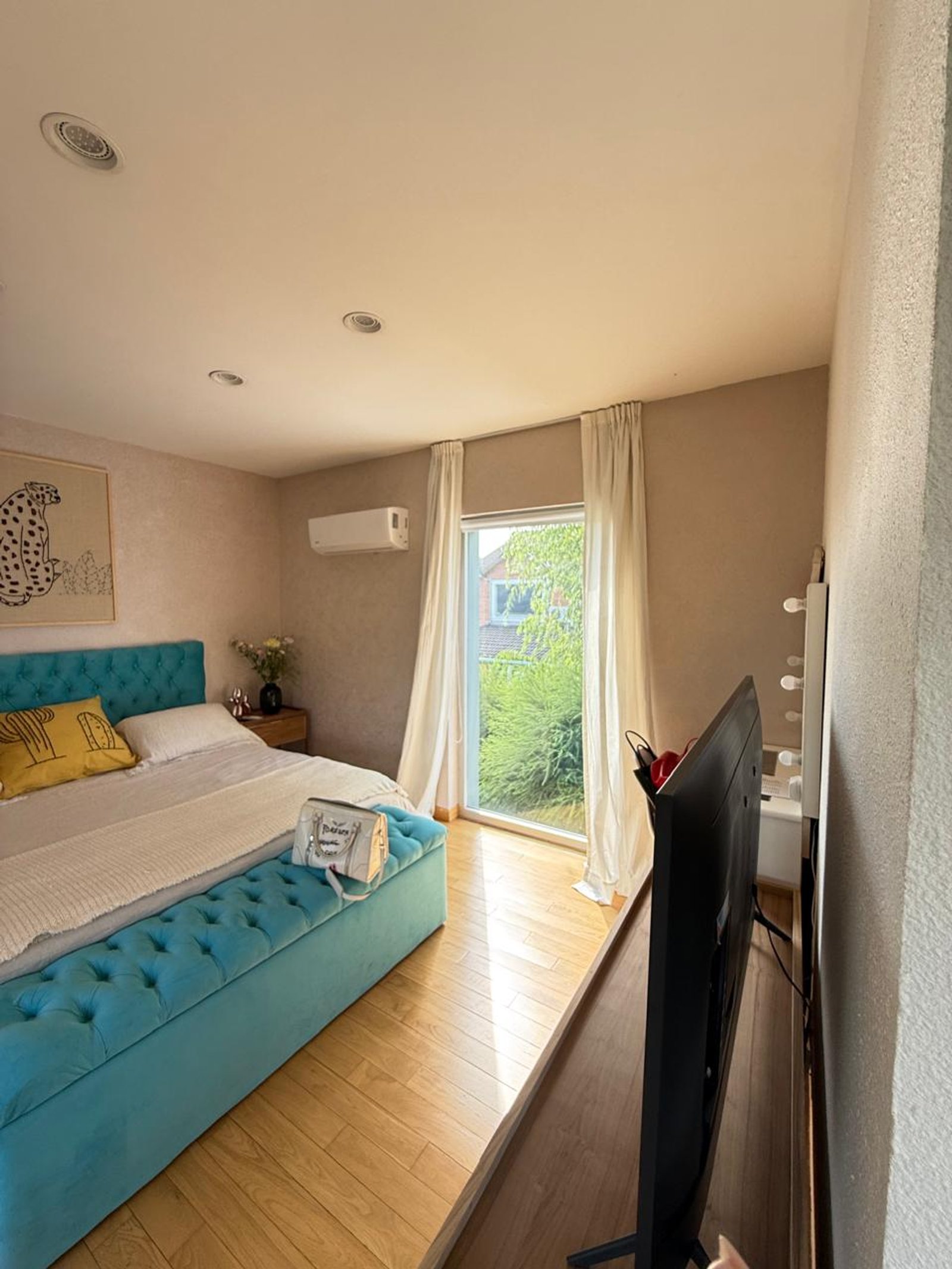 Dormitorio moderno con banco tapizado turquesa y arte de leopardo — proyecto Dormitorio, por ecodecor argentina, en Buenos Aires