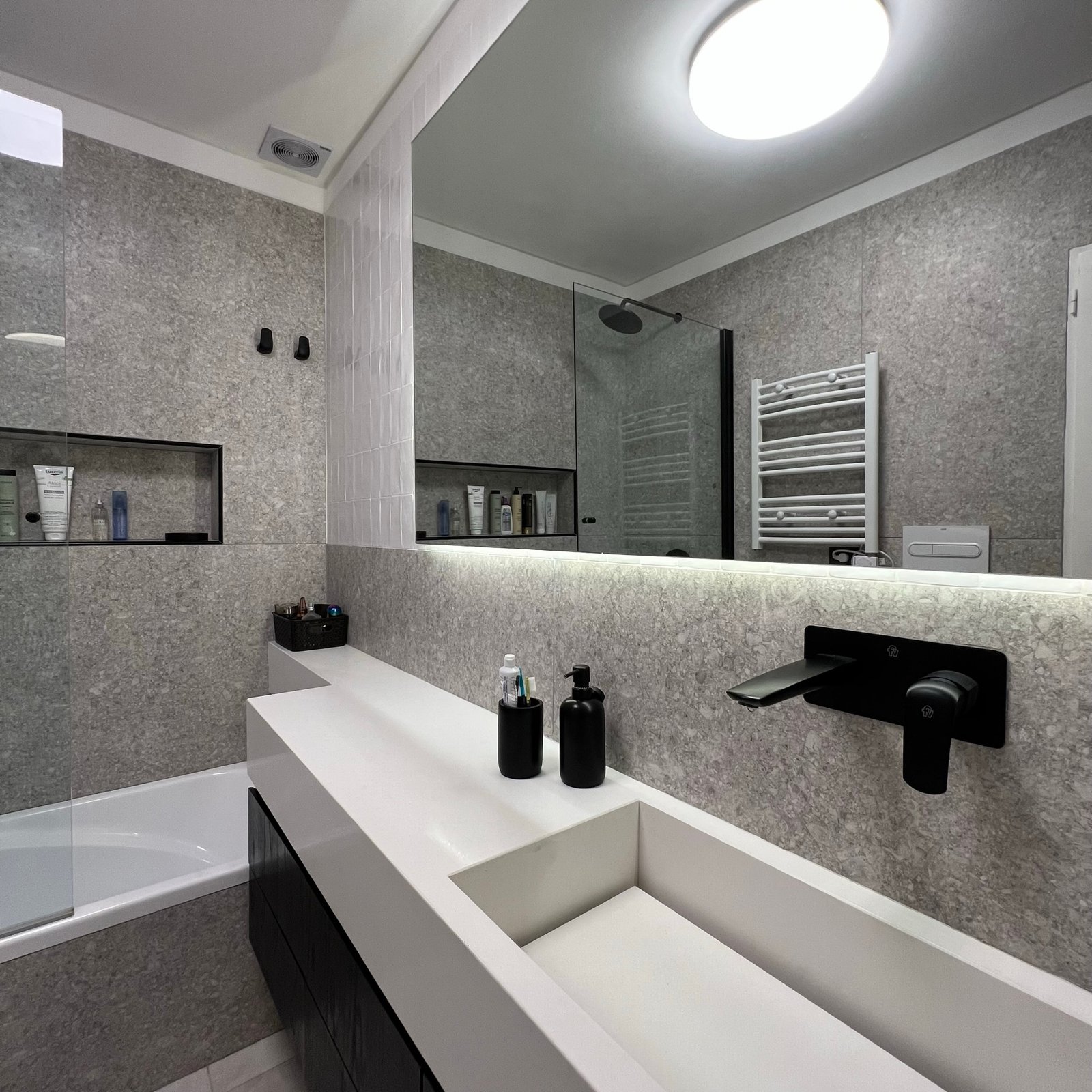 Baño moderno con lavabo integrado y grifería negra mural — proyecto Cranwell, por MDBK Arquitectura, en Flores