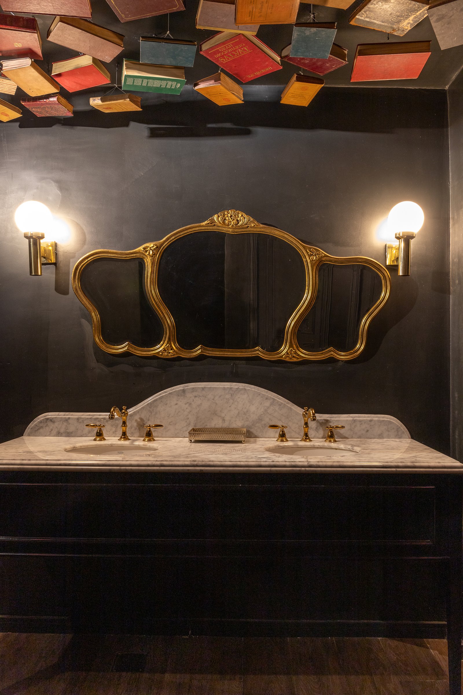 Baño con vanitory doble, espejo dorado y libros en el techo — proyecto PRESIDENTE BAR HIPODROMO, por AB ARQUITECTURA, en San Isidro