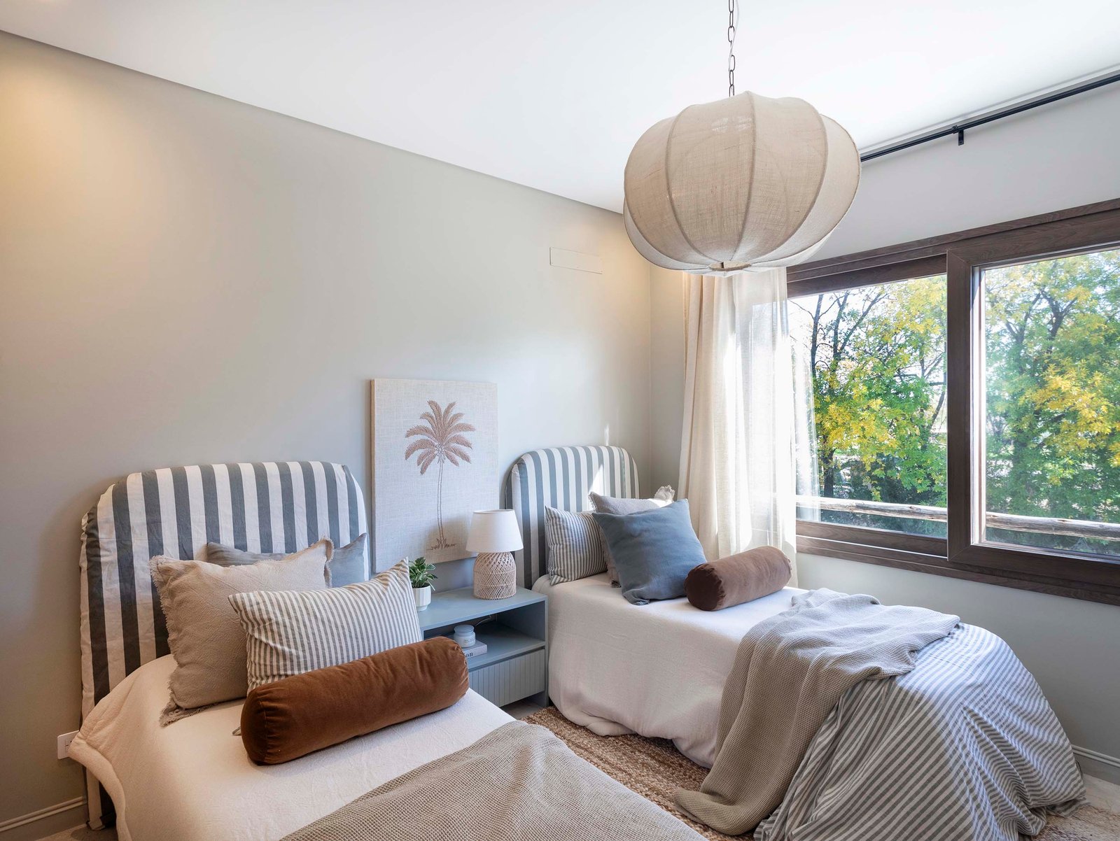 Dormitorio moderno con dos camas, lámpara esférica y detalles nórdicos — proyecto El Descanso, por MUCHTEK, en Provincia de Buenos Aires