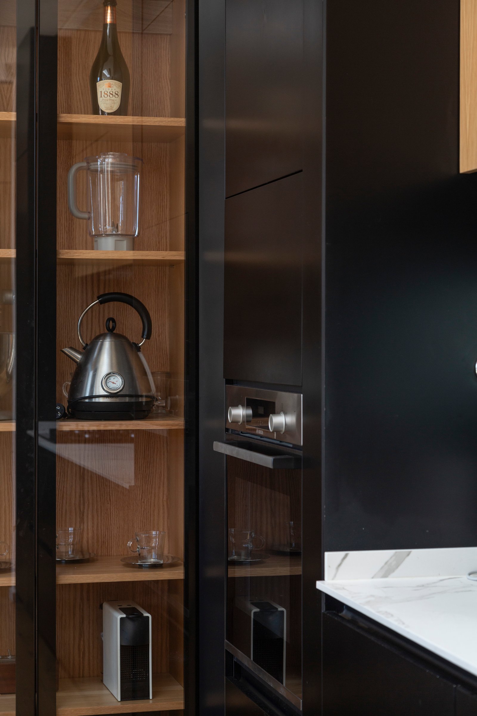 Cozinha moderna com armários pretos integrados e prateleiras de madeira — projeto Casa MECHA, por Grupo CRBN, em B1712 Castelar