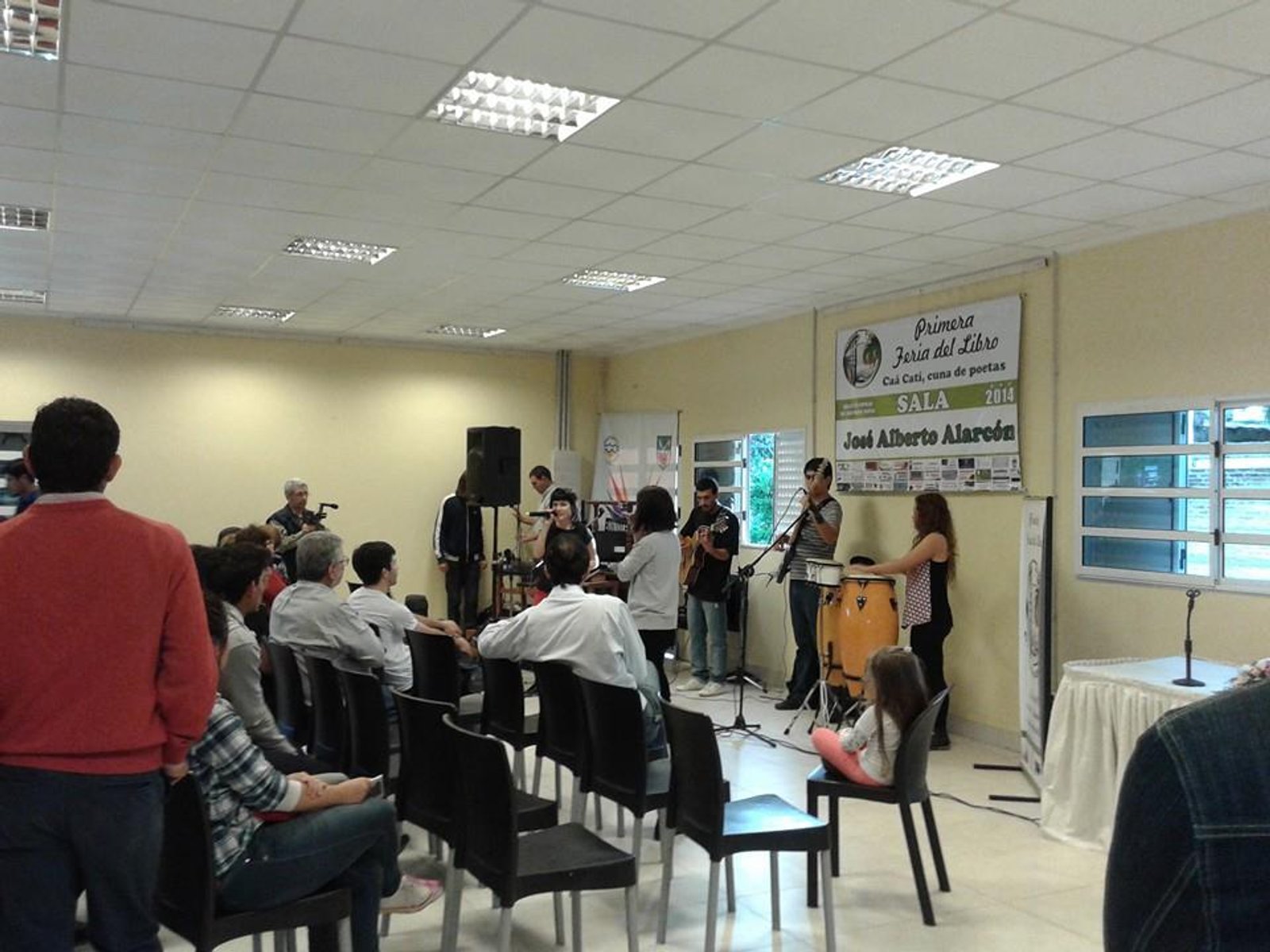 Espacio interior con banda tocando en vivo para una audiencia — proyecto Biblioteca Publica, Dr. Juan Manuel Rivera. Caa Cati, Corrientes., por Arquitecto Gustavo Maidana, en Caá C
