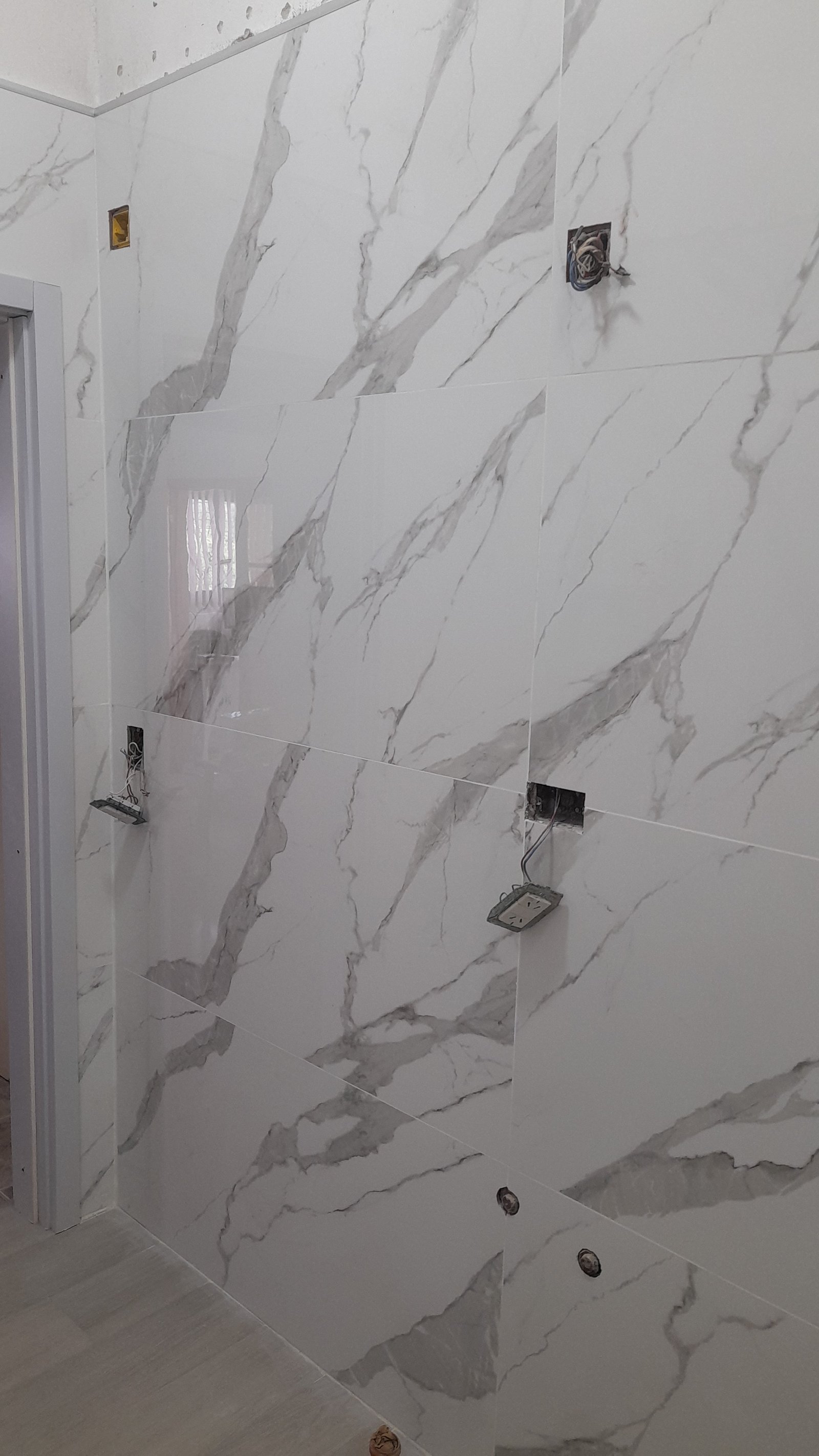 Baño en construcción con azulejos de mármol gris y beige — proyecto Remodelación de baño, por CN Construcciones, en Alta Gracia