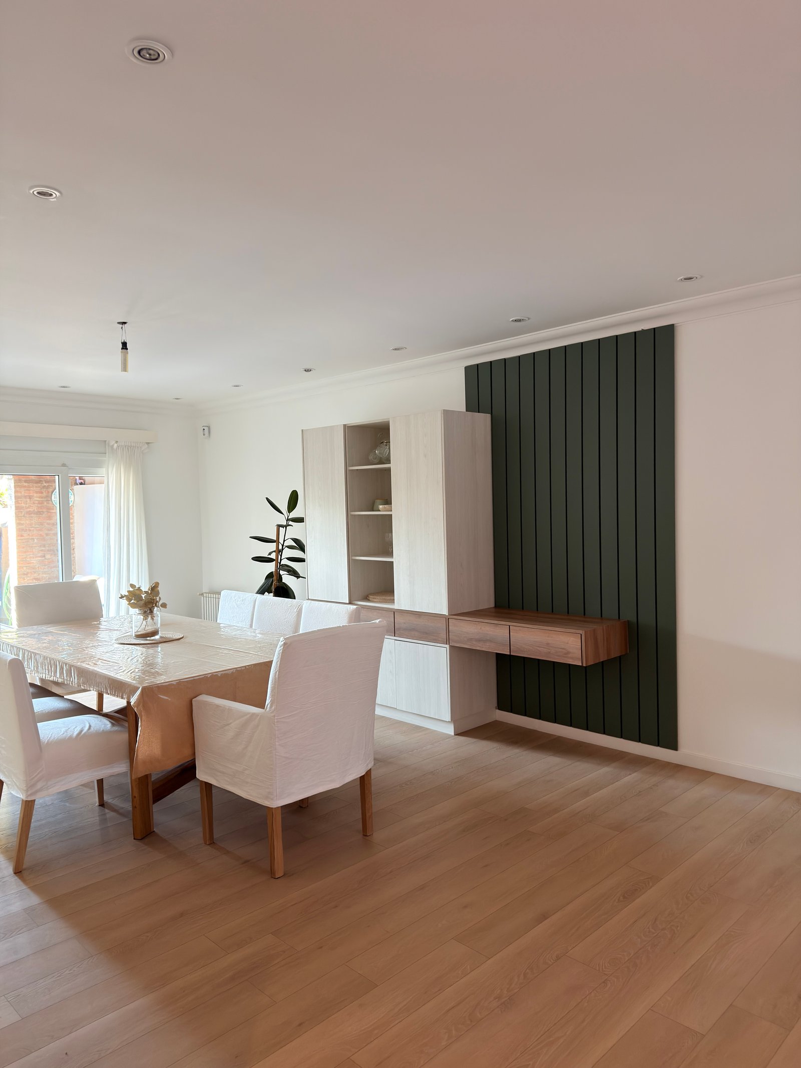 Sala de jantar moderna com painéis de parede canelados verdes e mesa coberta — projeto SAN ISIDRO, por Estudio Grupo 32, em San Isidro