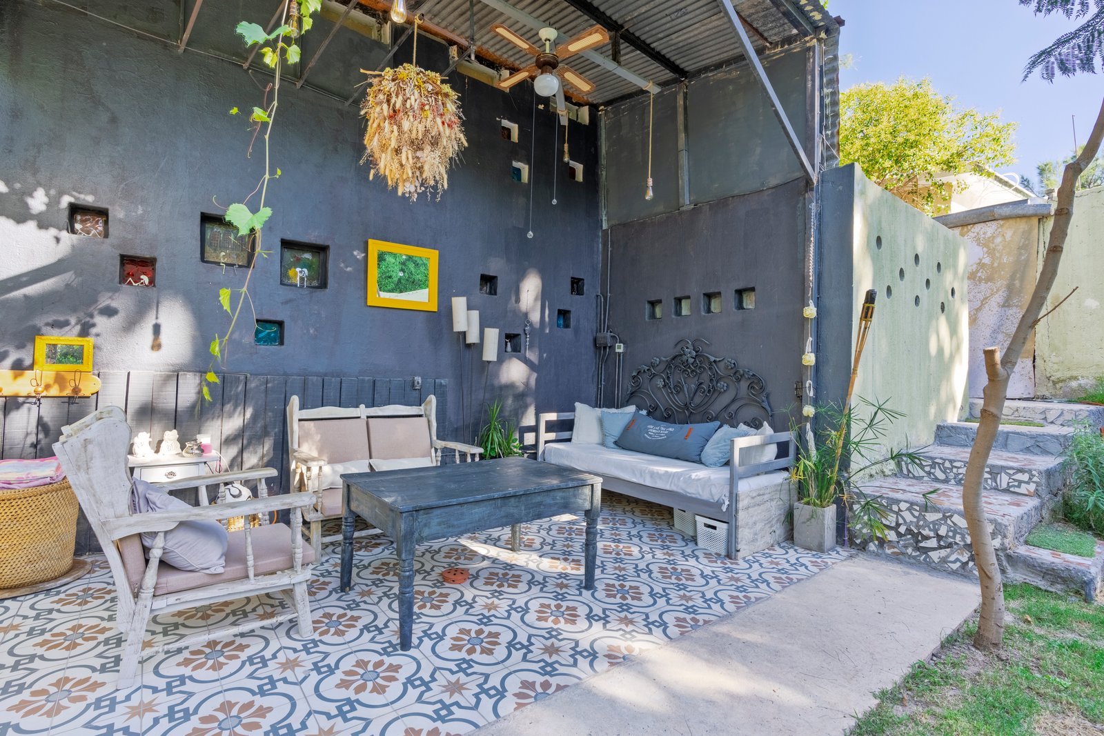 Patio boho con muebles de ratán y piso de baldosas — proyecto En el Taller, por Cristóbal Peña y Lillo, en Mendoza