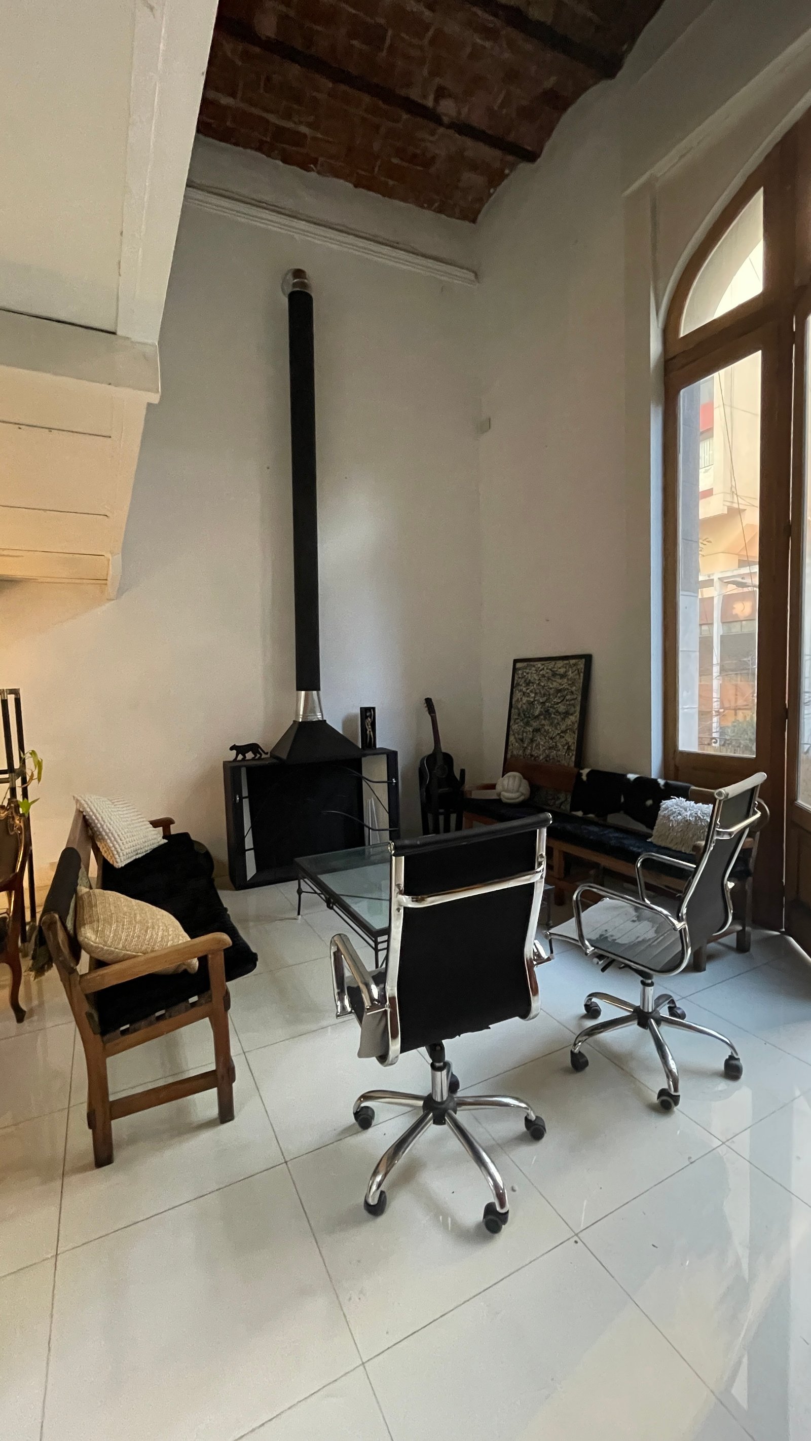 Living moderno con vigas de ladrillo expuesto y chimenea industrial — proyecto Espacio BALVAN, por DE DIOS Estudio, en Balvanera