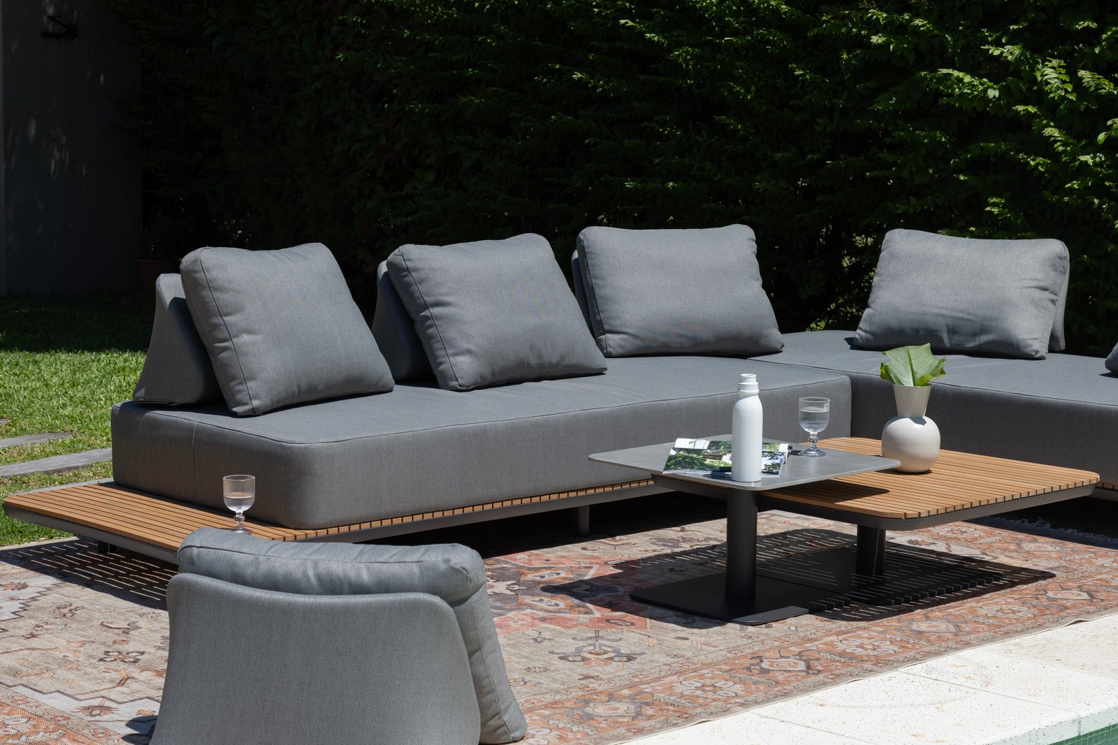 Sofá modular gris para exterior con mesa baja y deck — proyecto Nuevos diseños de Muebles de Exterior , por DESDE ASIA, en Malabia 1359