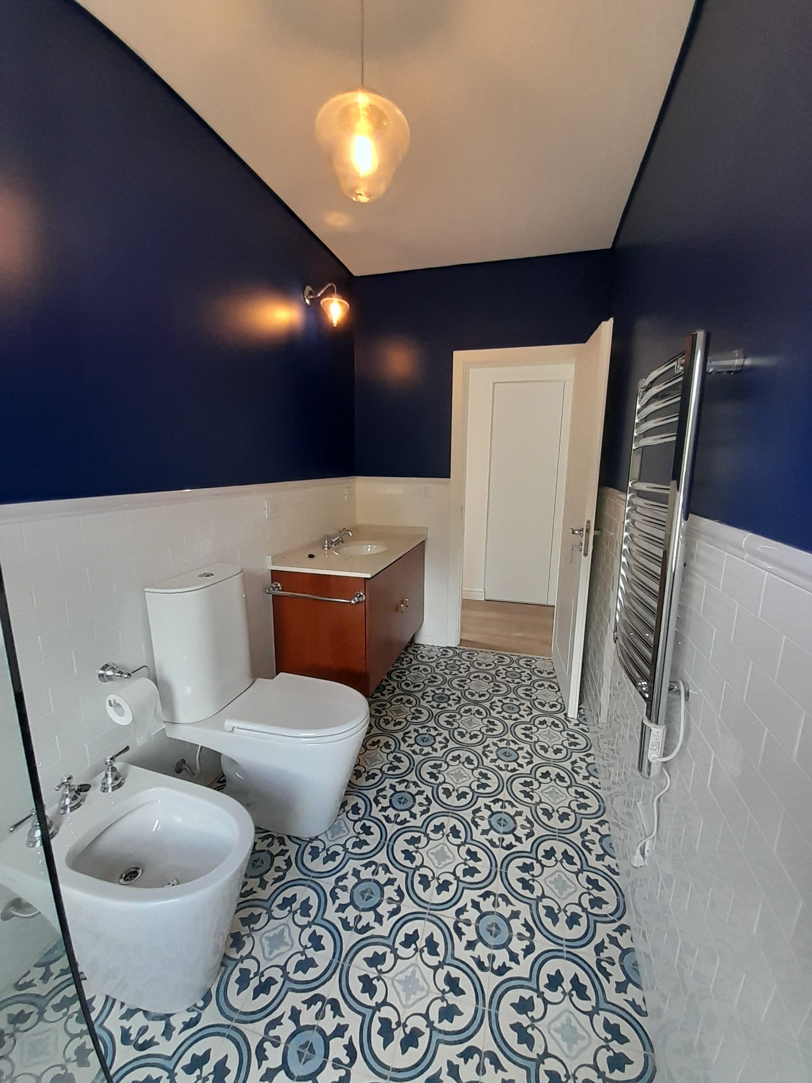 Banheiro moderno com azulejos estampados e paredes azuis — projeto Casa de Campo, por Estudio Fernandez Long & asoc., em San Andres de Giles