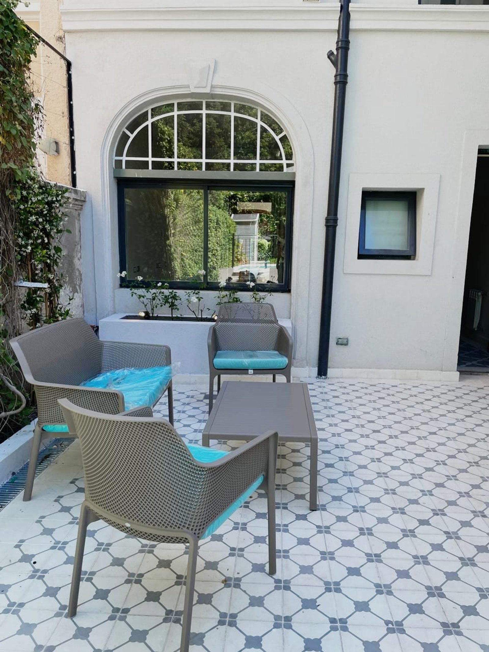 Patio exterior moderno con muebles grises y cojines azules — proyecto Living Exterior, por Casa Nuñez