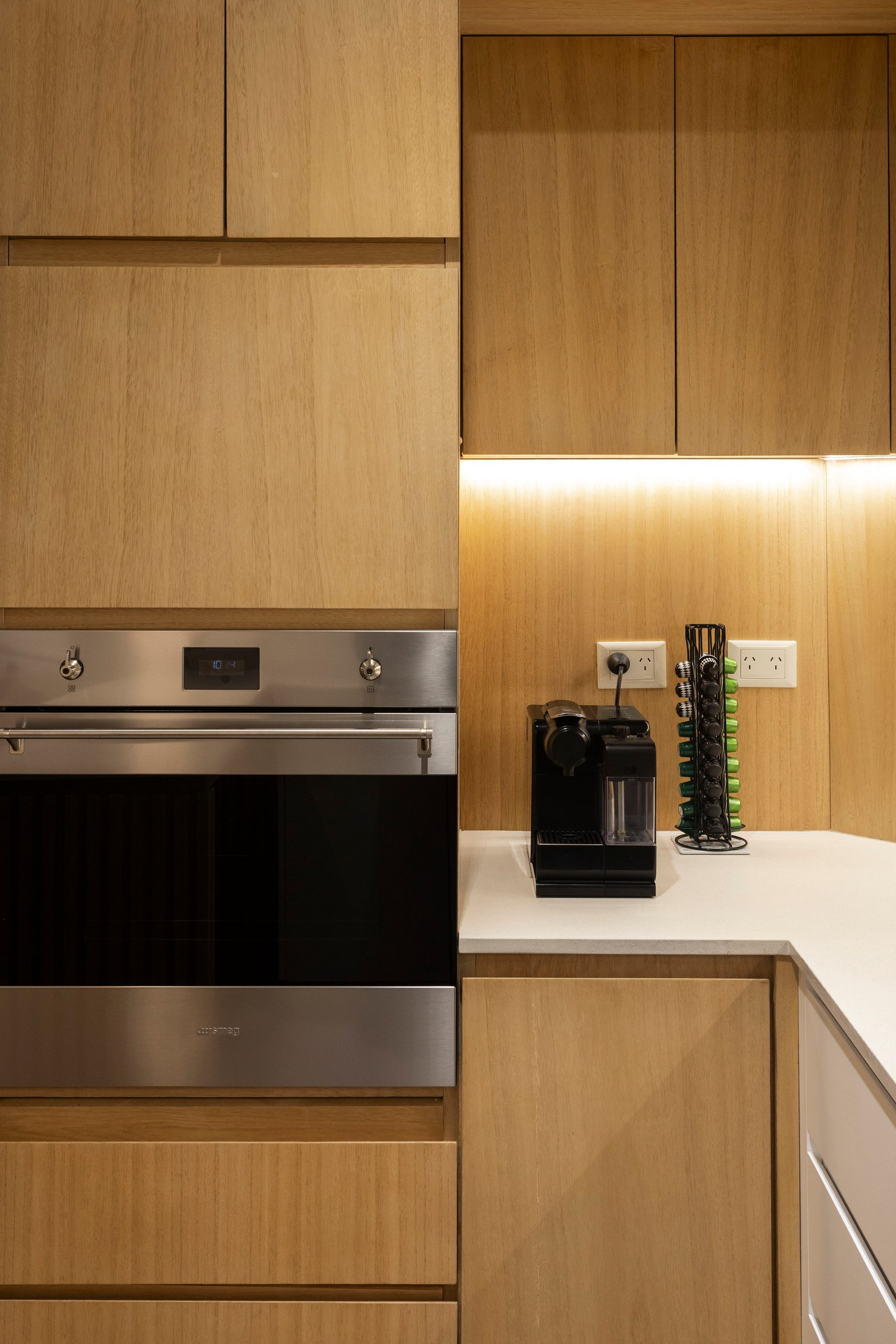 Cocina moderna con muebles de madera natural y horno empotrado — proyecto BARRACAS, por La Nave Arq., en Barracas