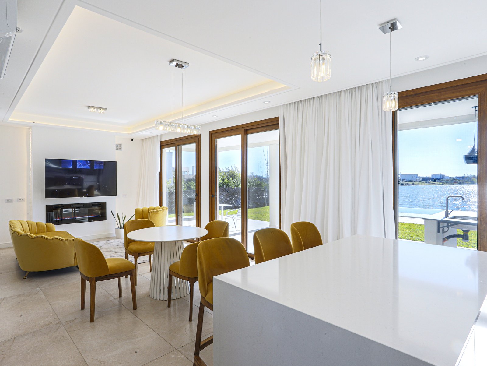 Sala de jantar moderna com vista para o mar e toques amarelos — projeto Casa SS182, por EZ architects, em M3CV+6H