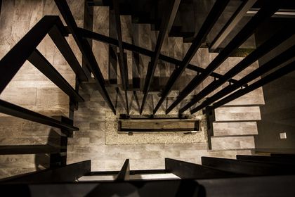 Escalera de hormigón con estructura metálica negra y luz natural — proyecto Casa MM, por Facundo Arana Arquitecto